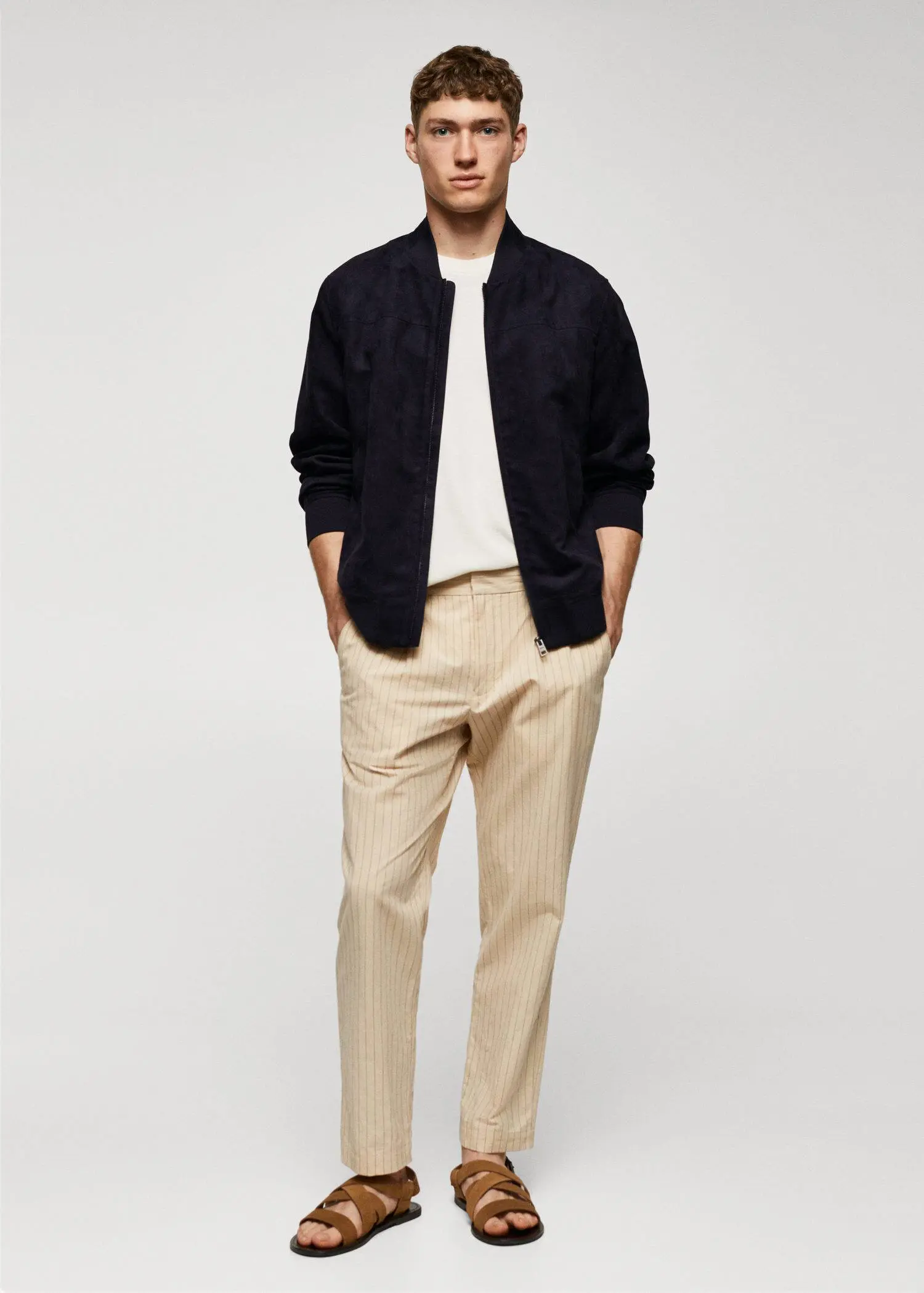 Mango Suede-effect bomber jacket. a man wearing a black jacket and beige pants. 