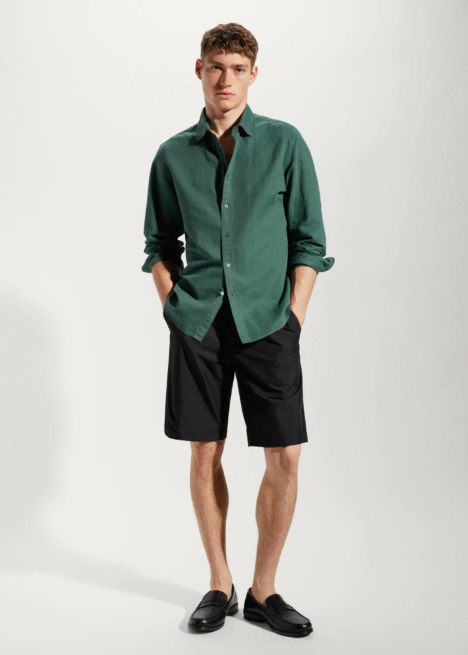 Mango Regular-fit linen cotton shirt. a man wearing a green shirt and black shorts. 