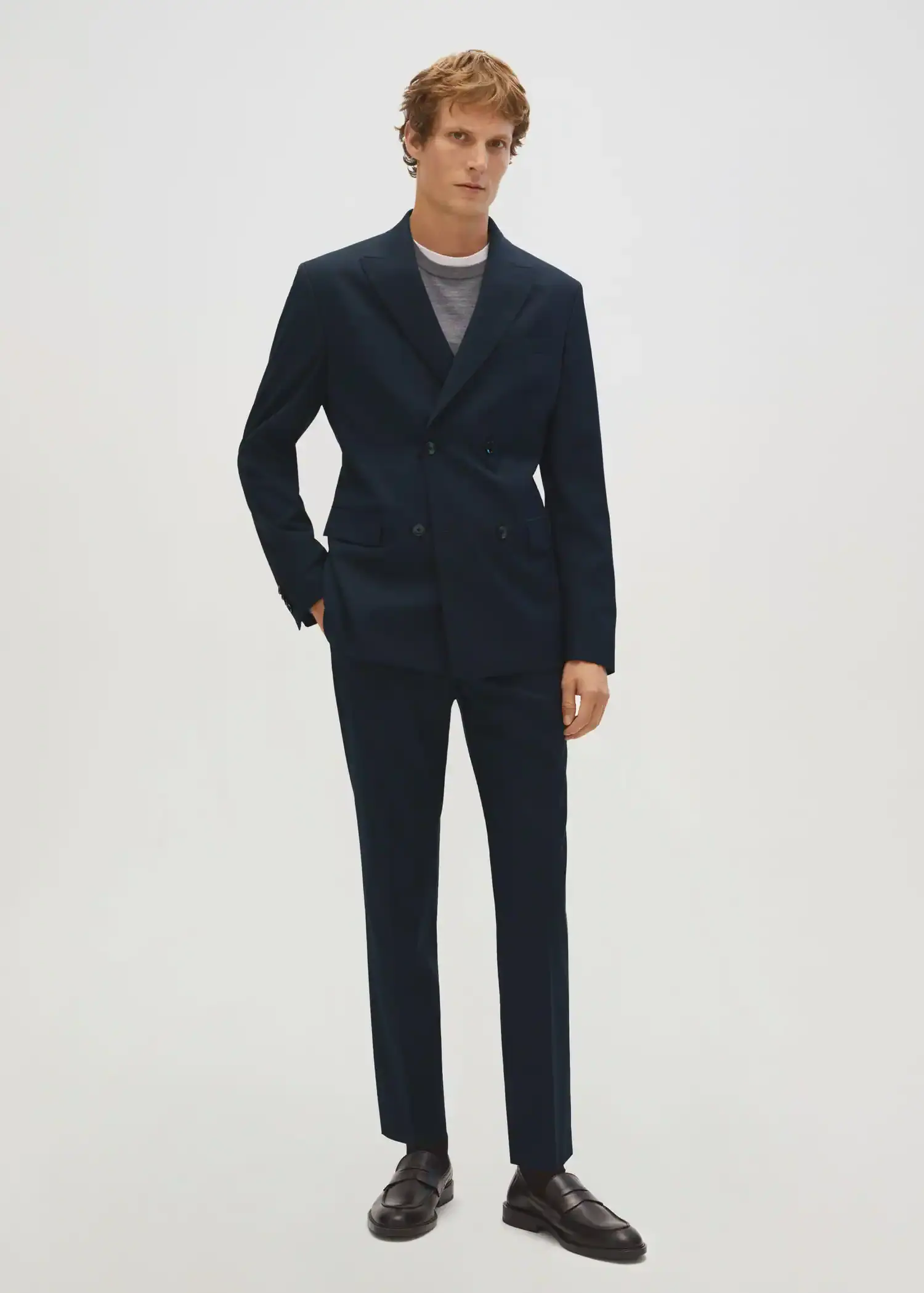Mango Slim fit double-breasted suit blazer. a man in a suit standing in front of a white wall. 