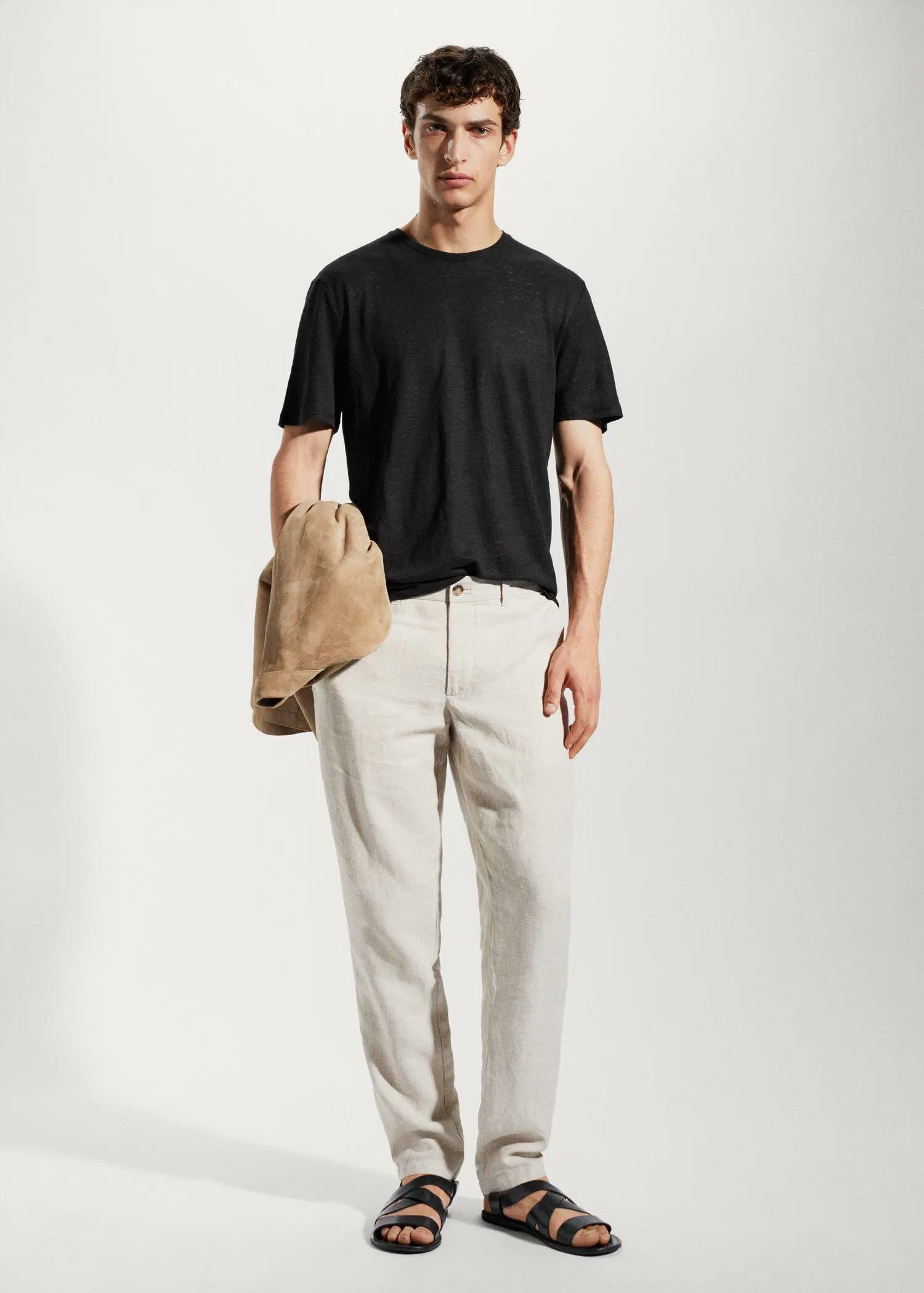 Mango 100% linen slim-fit t-shirt. a man in a black t-shirt holding a bag. 