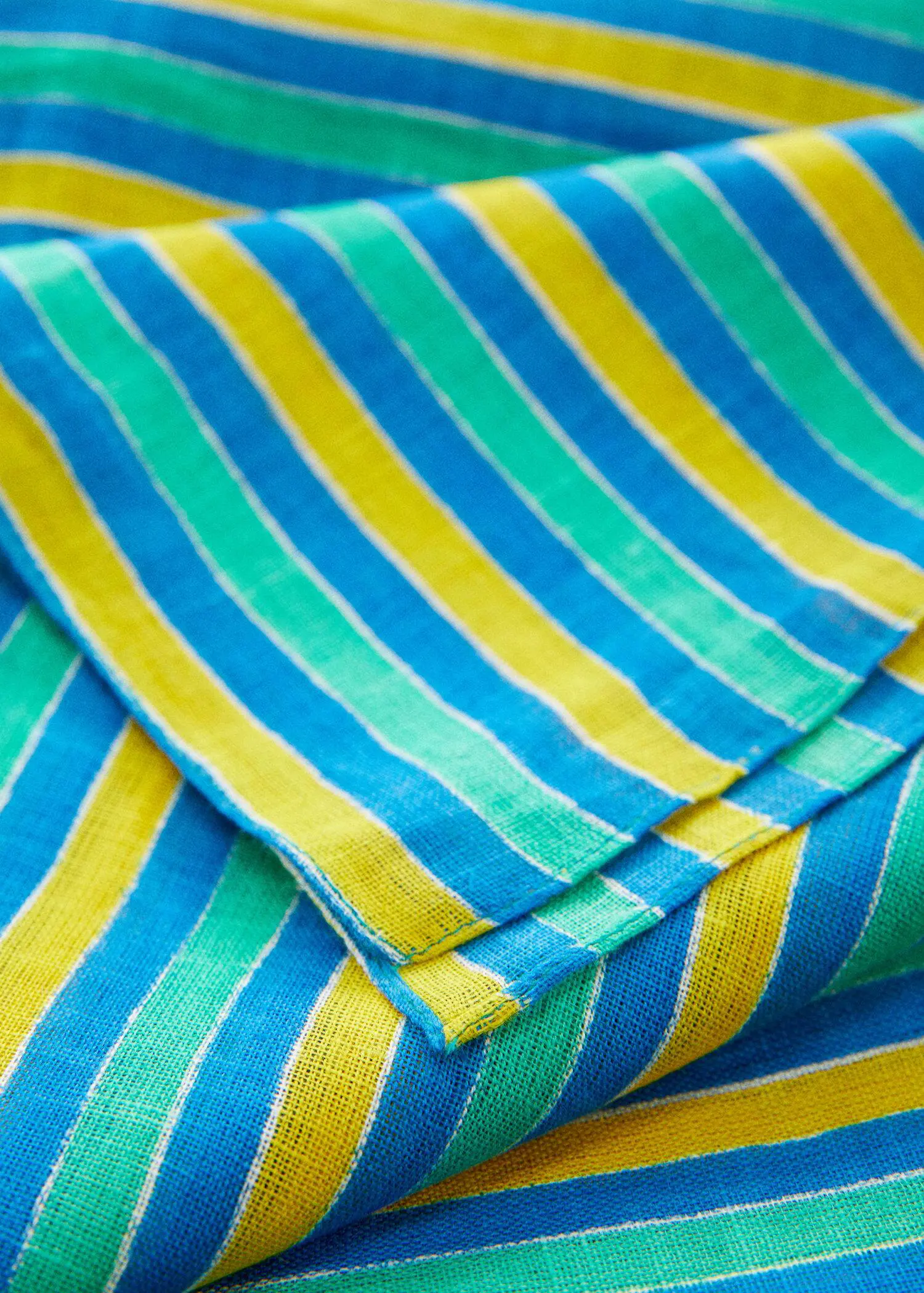 Mango Multi-colored striped linen sarong. a close-up view of a blue, yellow, and green striped cloth. 