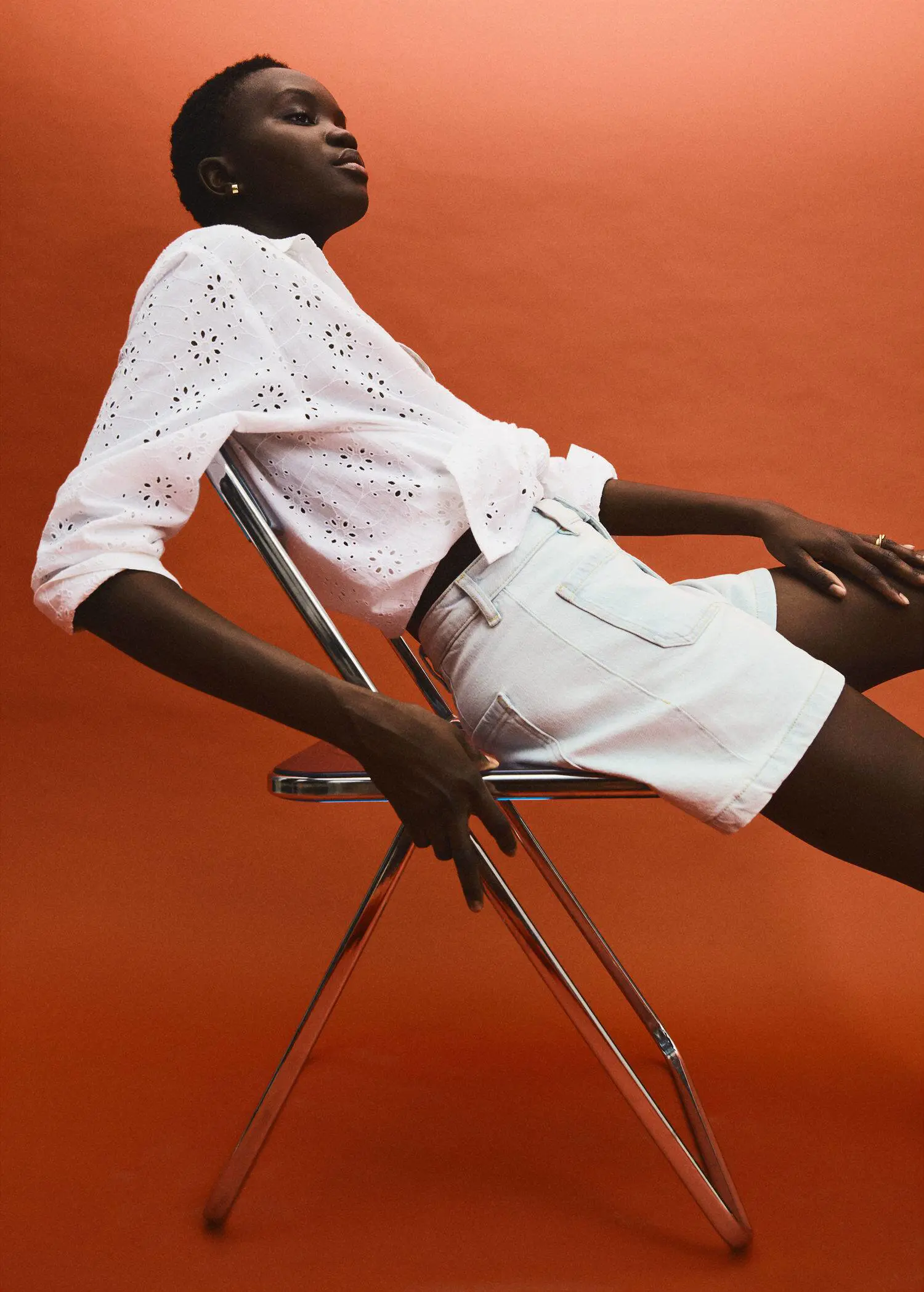Mango Slim denim shorts. a person sitting on a chair wearing white shorts. 
