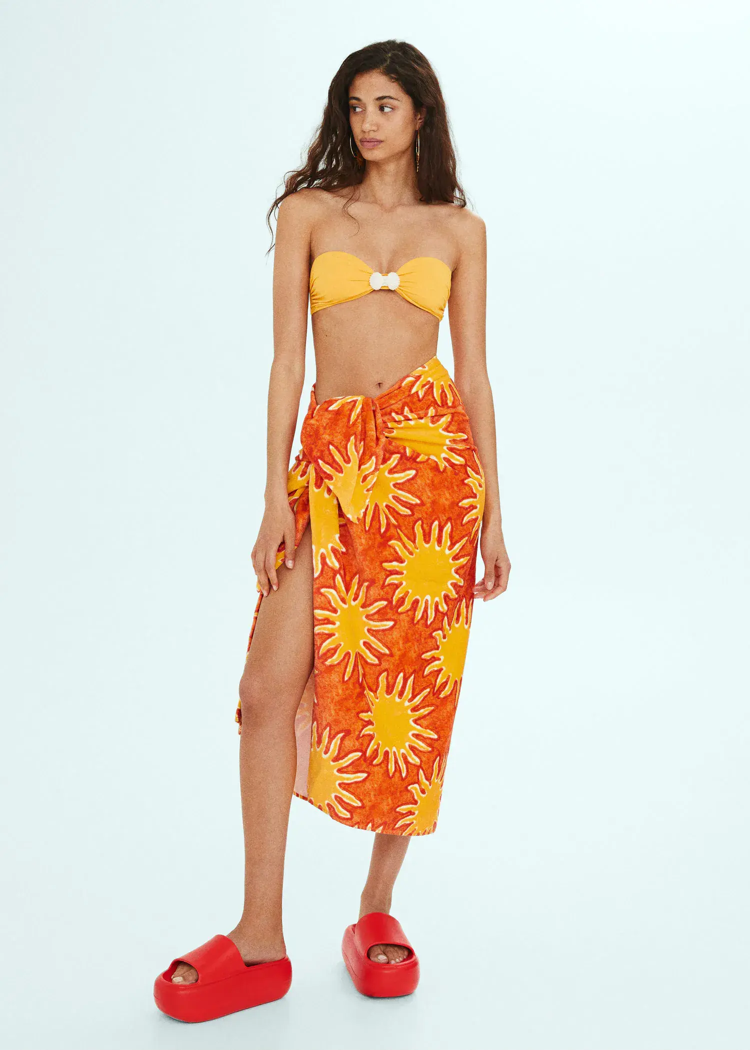 Mango 100% cotton printed towel. a woman wearing a sun-themed sarong and bikini top. 