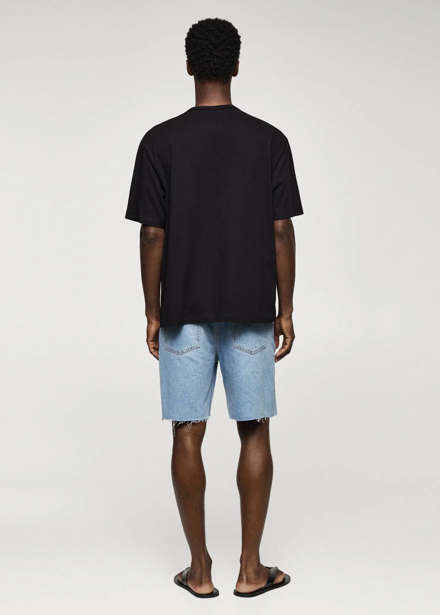Mango 100% cotton relaxed-fit t-shirt. a man in black shirt and blue denim shorts. 