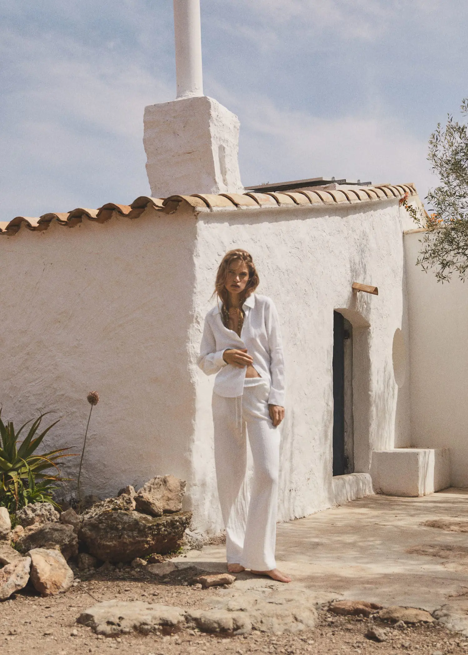 Mango Bow textured trousers. a woman standing in front of a white building. 