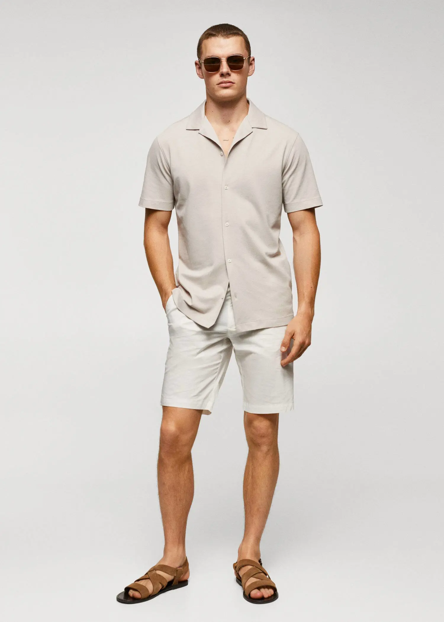 Mango Cotton pleated Bermuda shorts. a man in a tan shirt and shorts. 