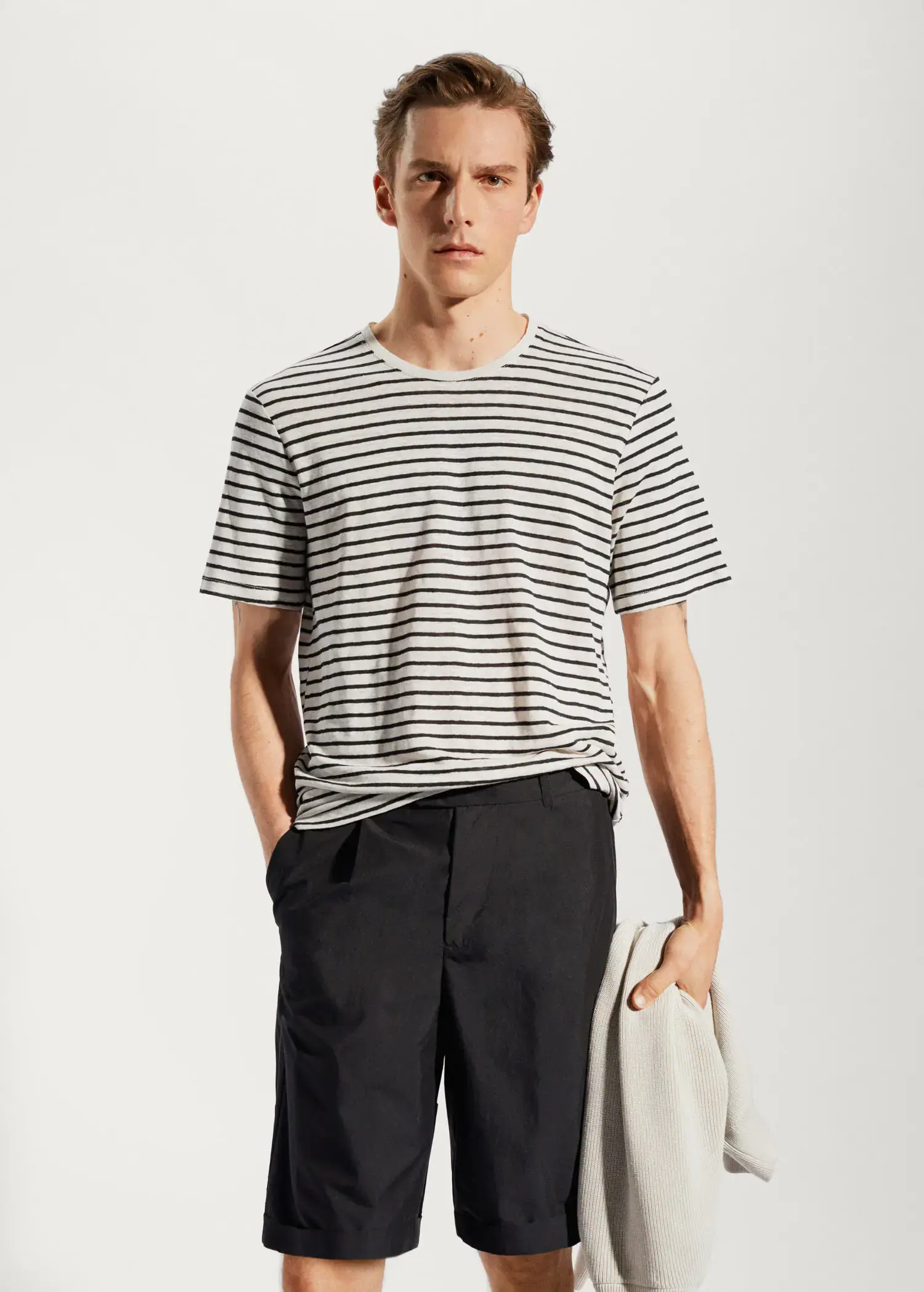 Mango 100% linen striped t-shirt. a young man wearing a striped shirt and black pants. 