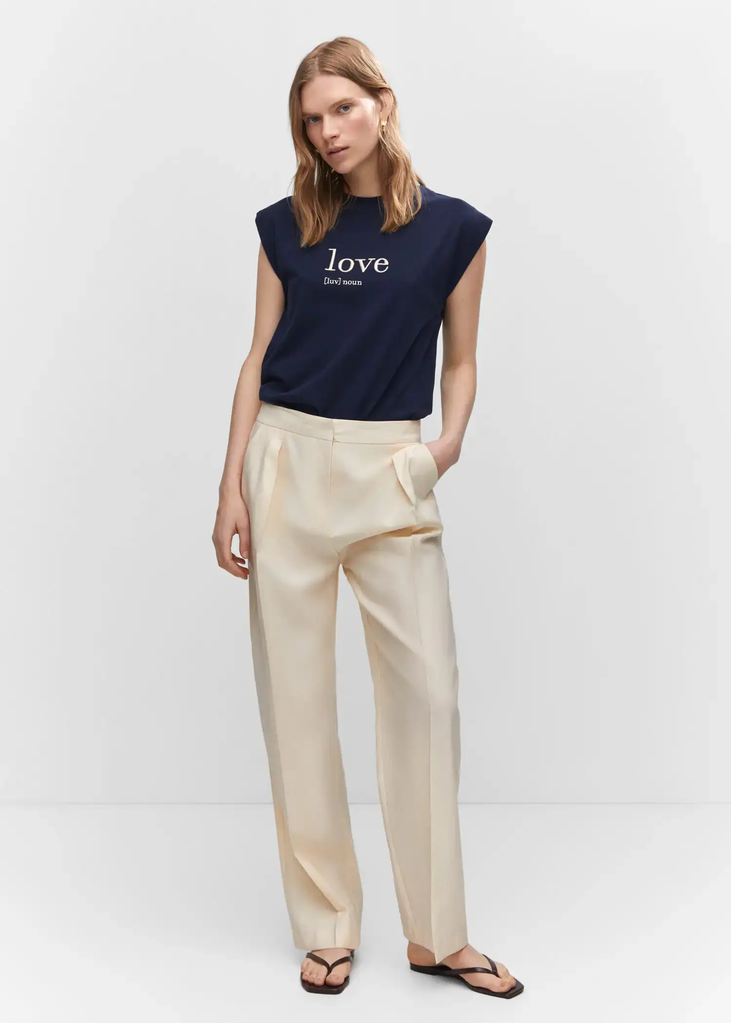 Mango Message cotton T-shirt. a woman in a navy blue shirt and white pants. 