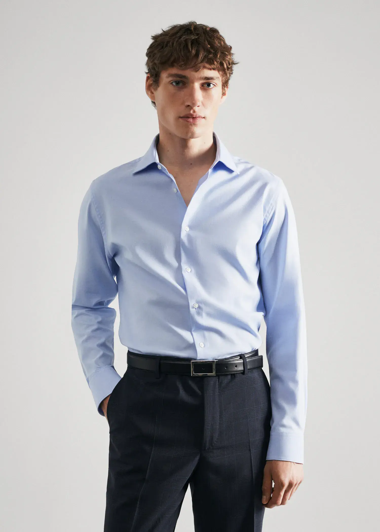 Mango Slim-fit cotton poplin suit shirt. a man wearing a blue shirt and black pants. 