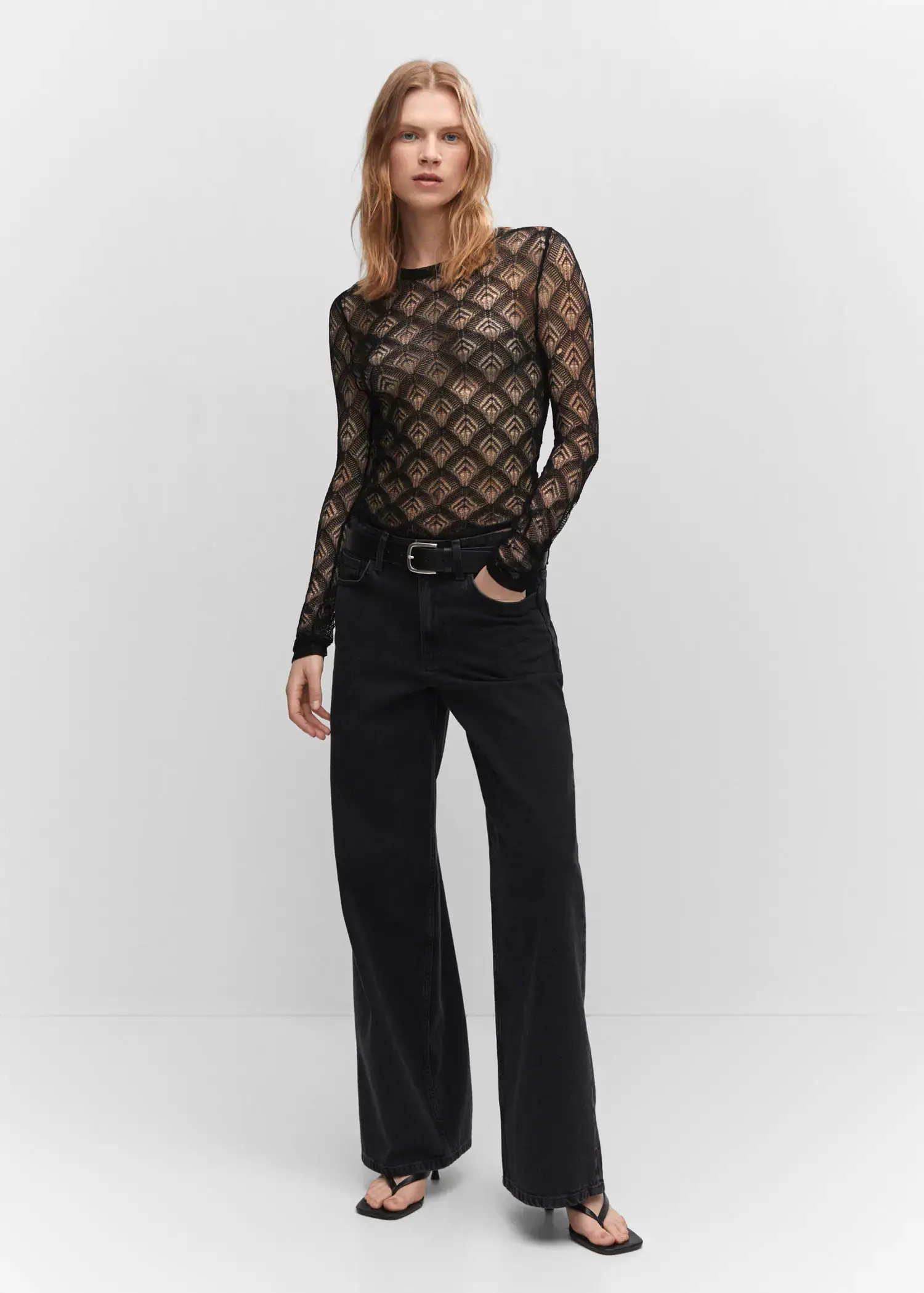 Mango Geometric openwork T-shirt. a woman wearing black pants and a see through top. 