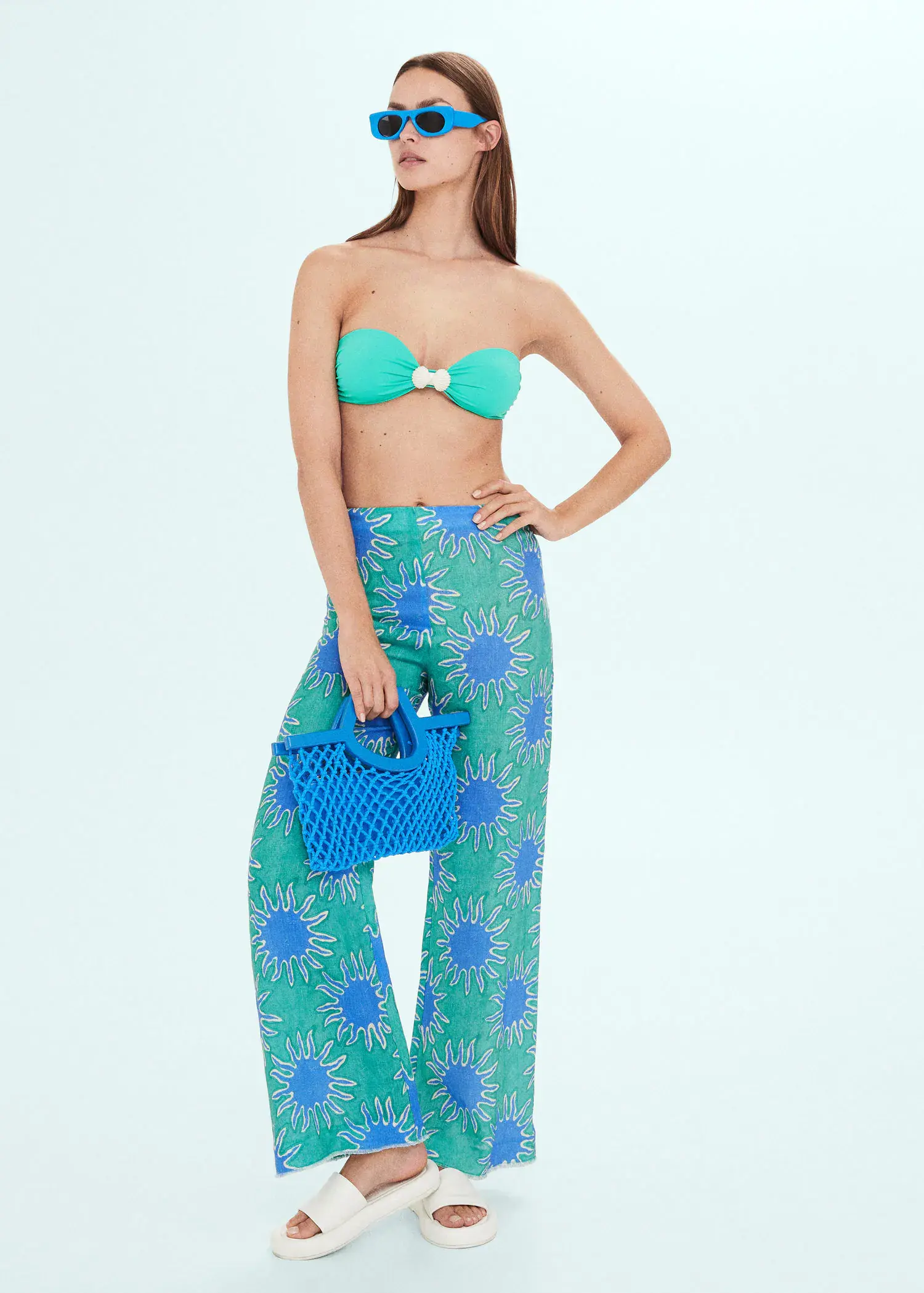 Mango Printed linen wideleg trousers. a woman holding a blue purse in front of a blue wall. 