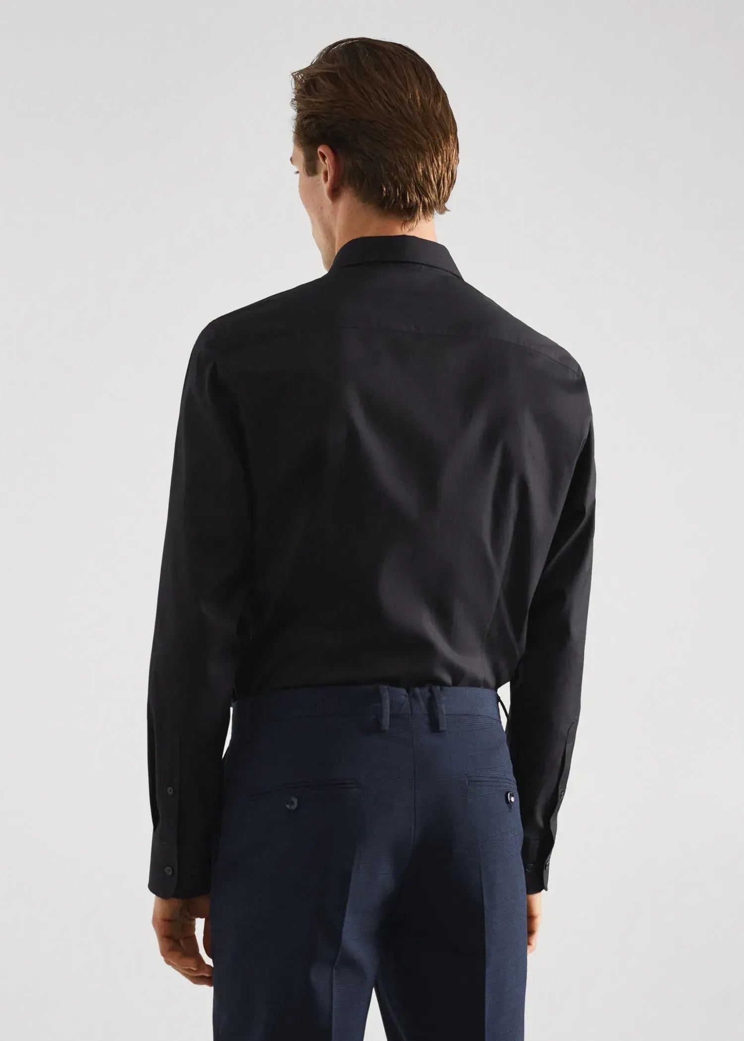 Mango Slim-fit cotton poplin suit shirt. a man wearing a black shirt and blue pants. 