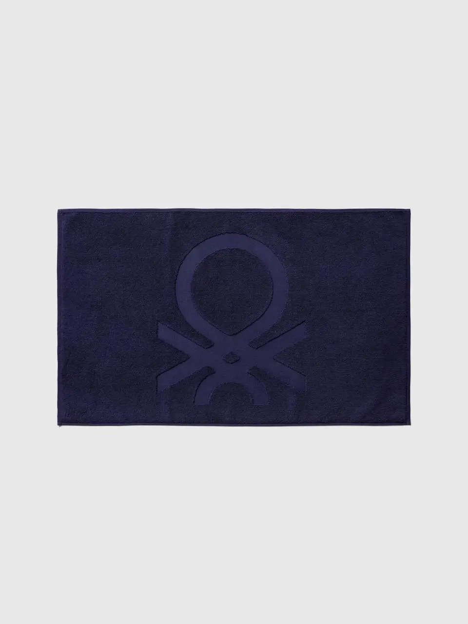 Benetton dark blue bathroom rug with logo. 1