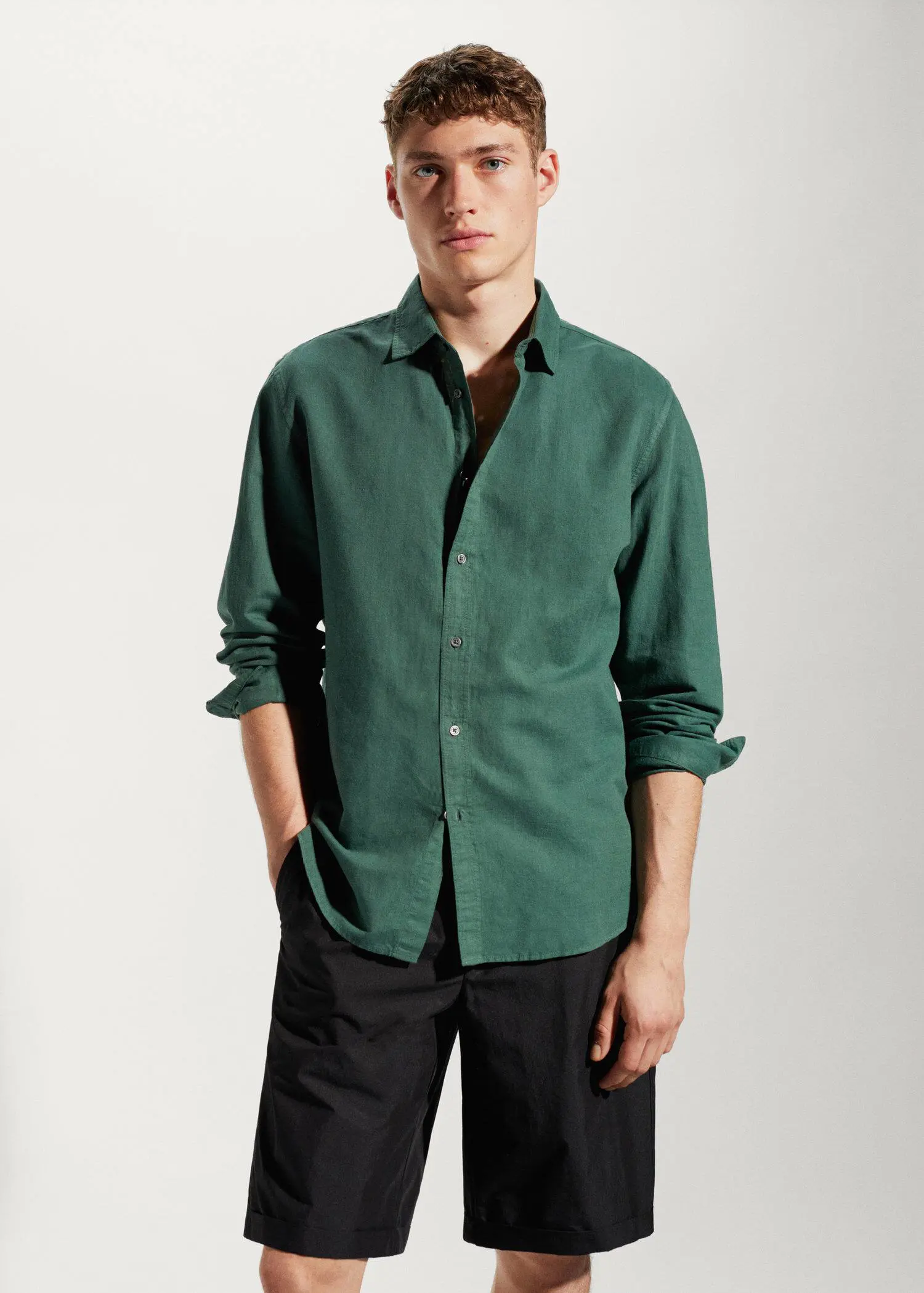 Mango Regular-fit linen cotton shirt. a man wearing a green shirt and black pants. 