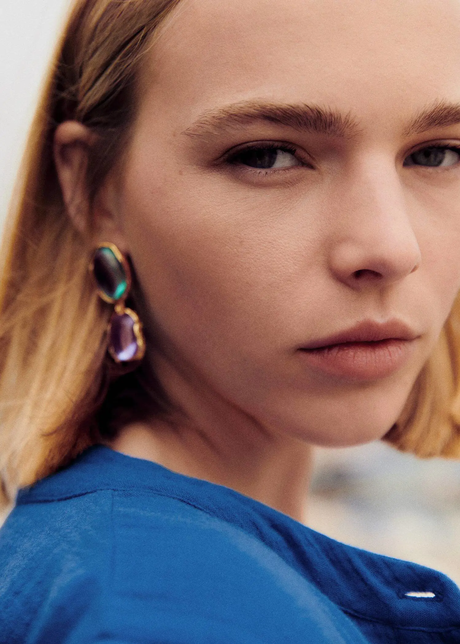 Mango Combined stones earrings. a close up of a person wearing a blue shirt 