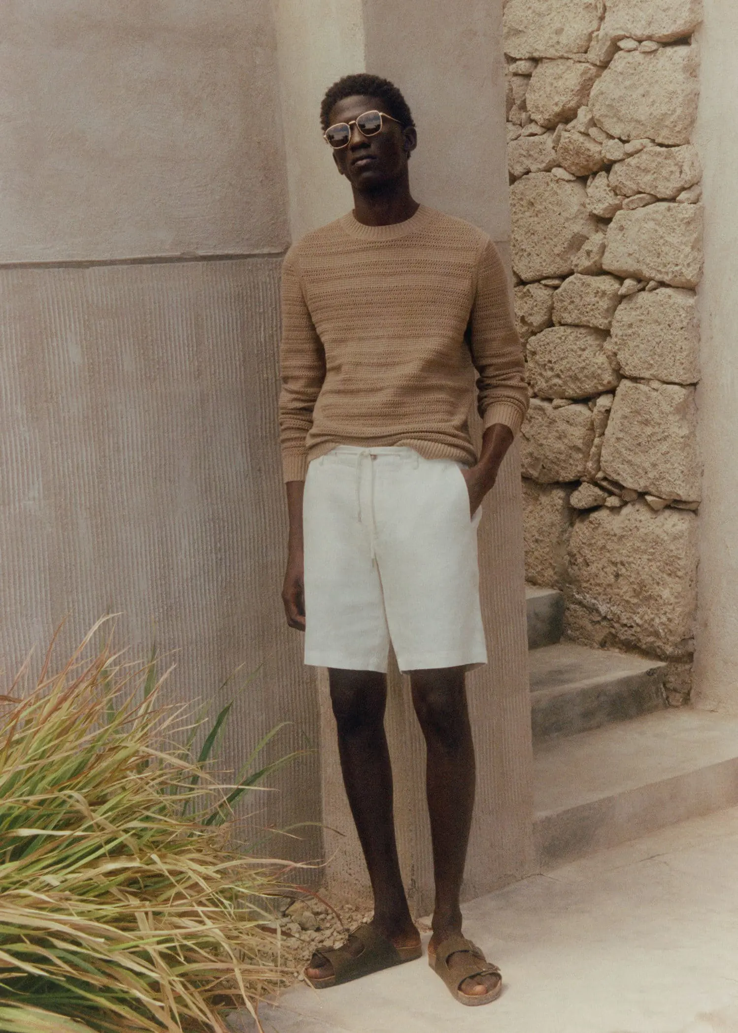 Mango 100% linen bermuda shorts with drawstring. a man standing in front of a stone wall. 