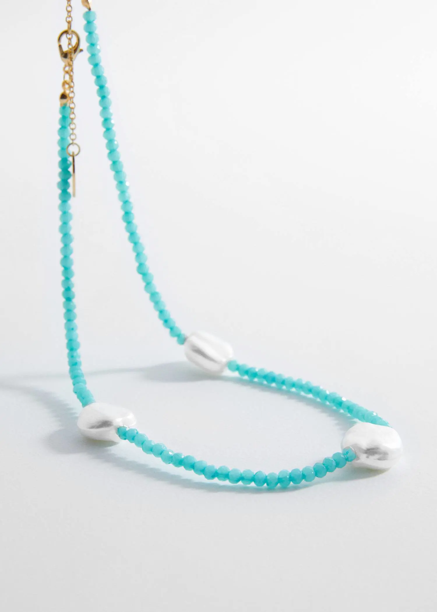 Mango Pearl beads necklace. a necklace with blue beads and white shells. 