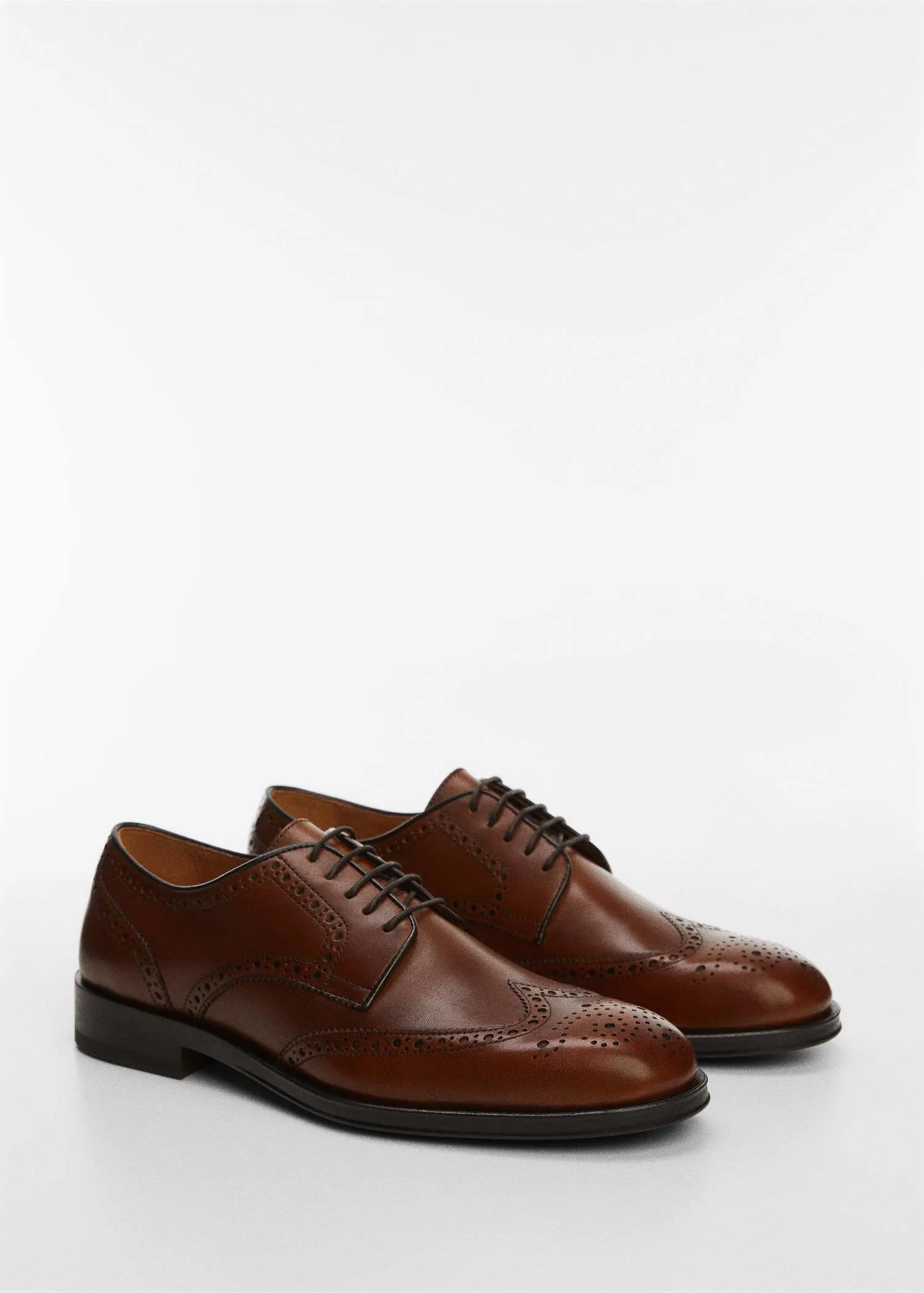 Mango Die-cut leather dress shoes. a pair of brown dress shoes on a white surface. 