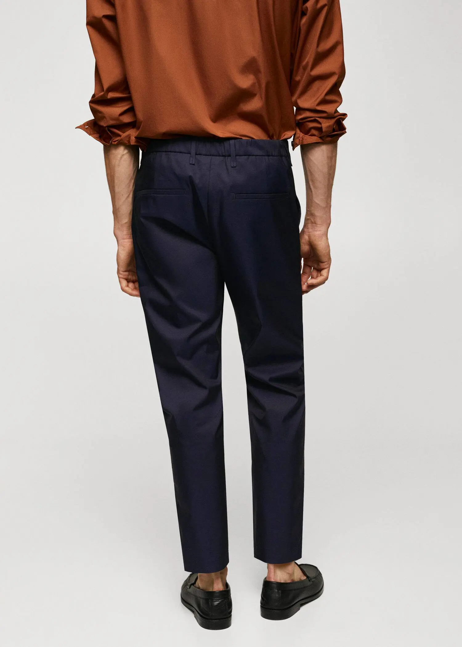 Mango Slim-fit cotton pants. a man wearing a brown shirt and black pants. 