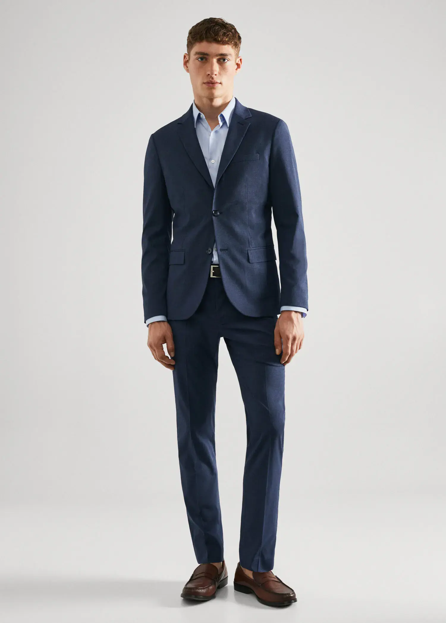 Mango Super slim-fit suit jacket in stretch fabric. a man in a suit standing in front of a white wall. 