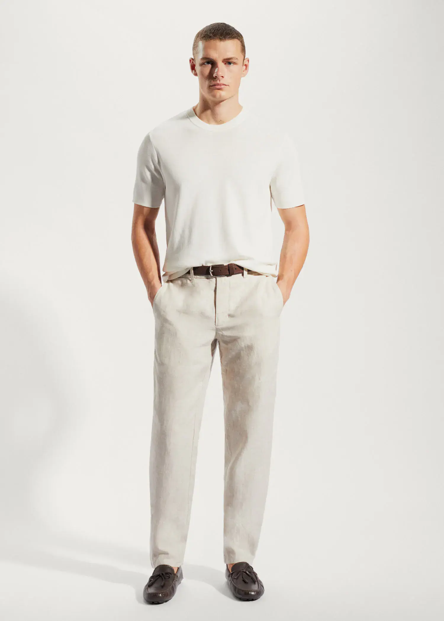 Mango Slim-fit 100% linen trousers. a man standing with his hands in his pockets. 