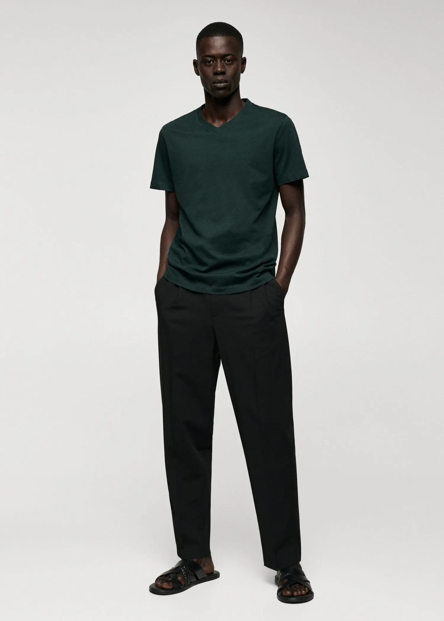Mango Basic cotton V-neck T-shirt. a man wearing a green shirt and black pants. 