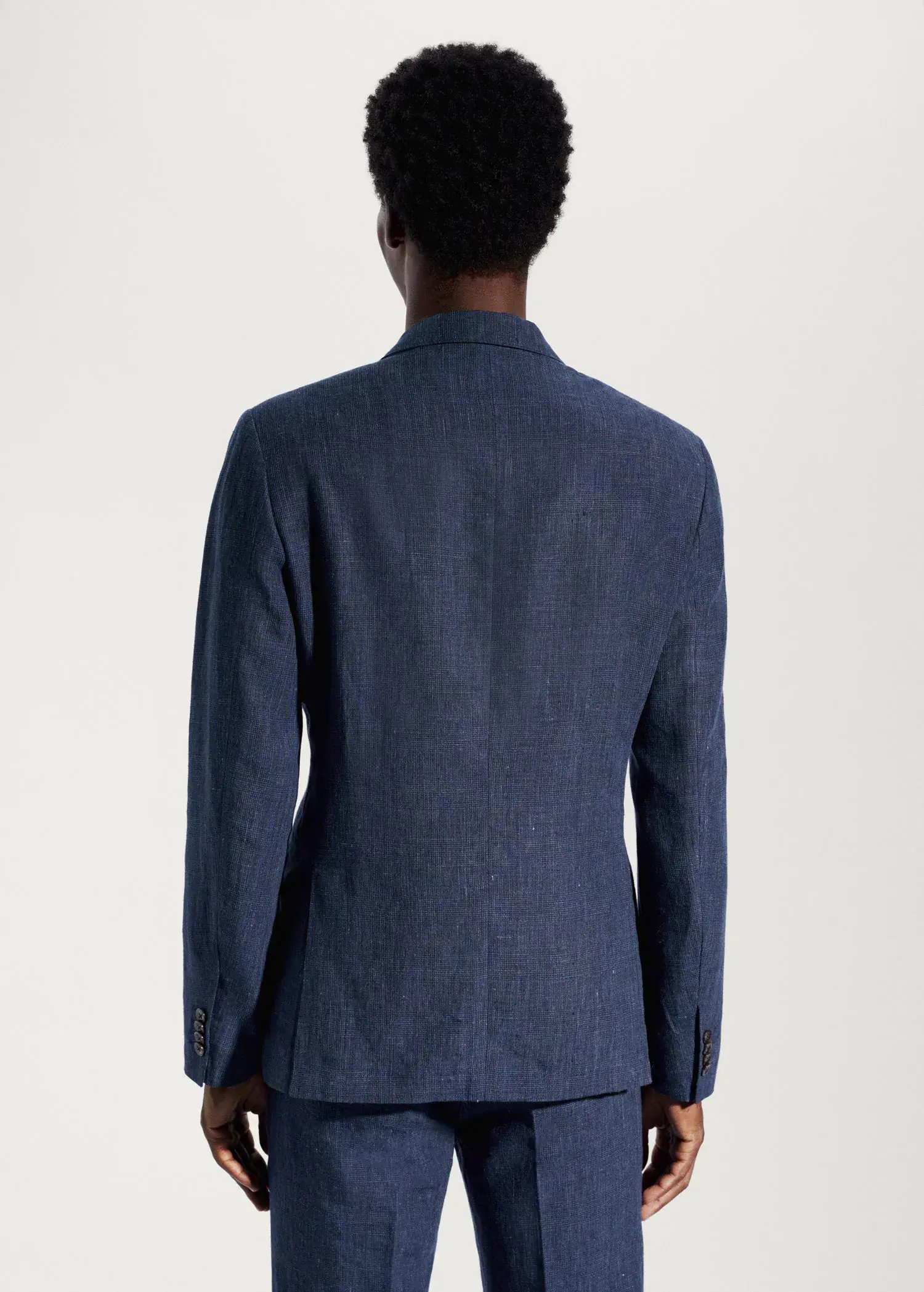 Mango Blazer suit 100% linen. a man wearing a blue suit standing in front of a white wall. 