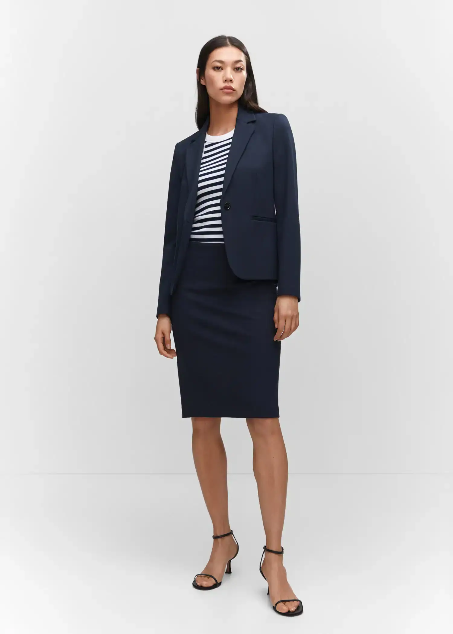 Mango Fitted jacket with blunt stitching. a woman in a black skirt and a striped shirt. 