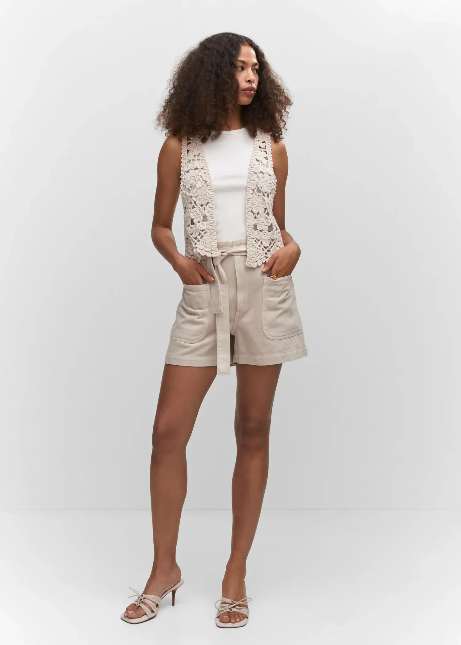 Mango Fringed gilet. a woman wearing a white shirt and a beige vest. 