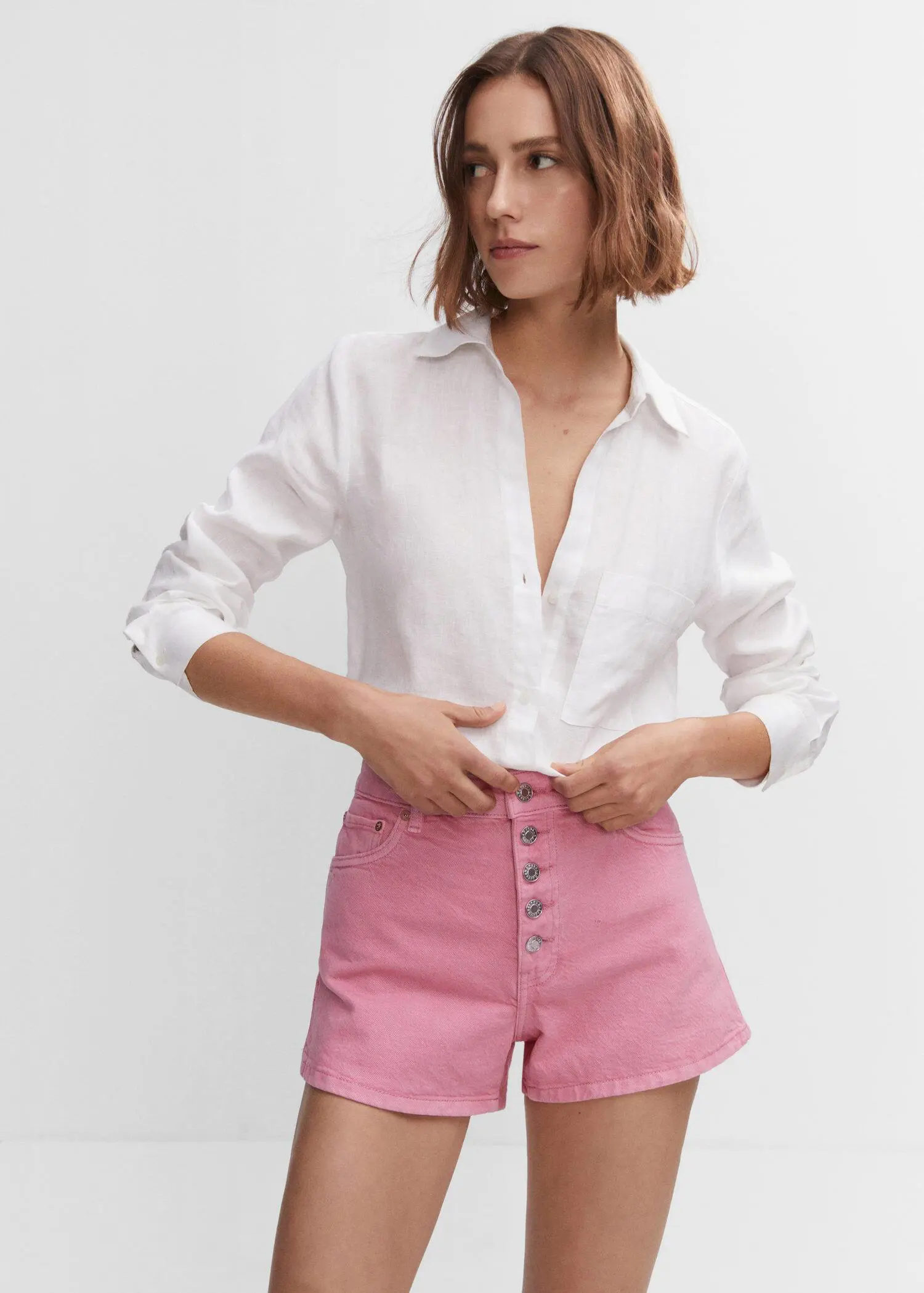Mango Denim shorts with buttons. a woman in white shirt and pink shorts. 