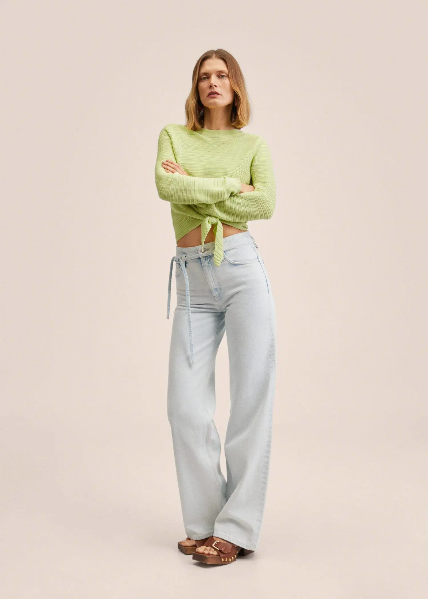 Mango Ribbed sweater with knot. a woman in a lime green sweater and light blue jeans. 
