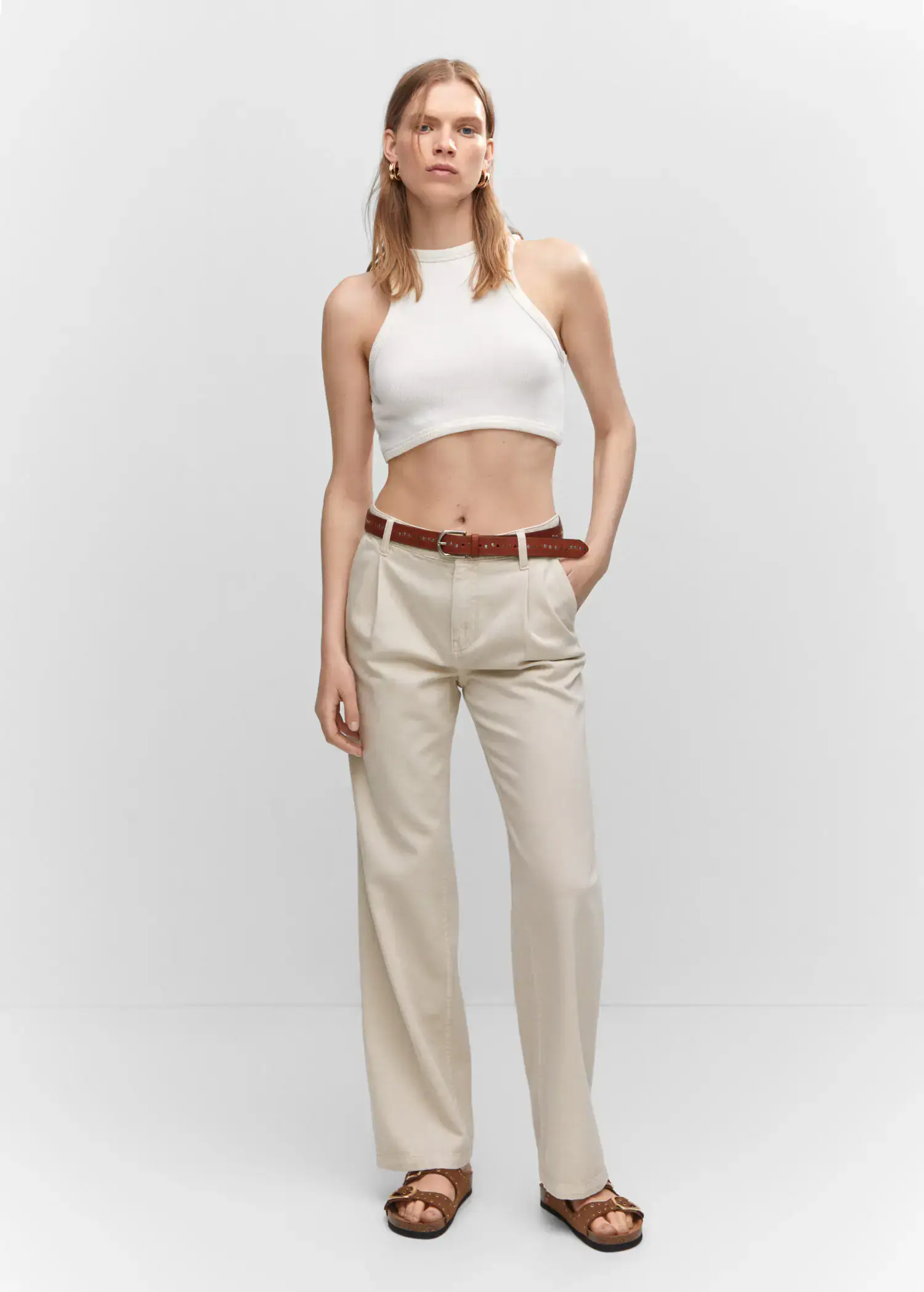 Mango Straight pleated jeans. a woman wearing a white top and beige pants. 