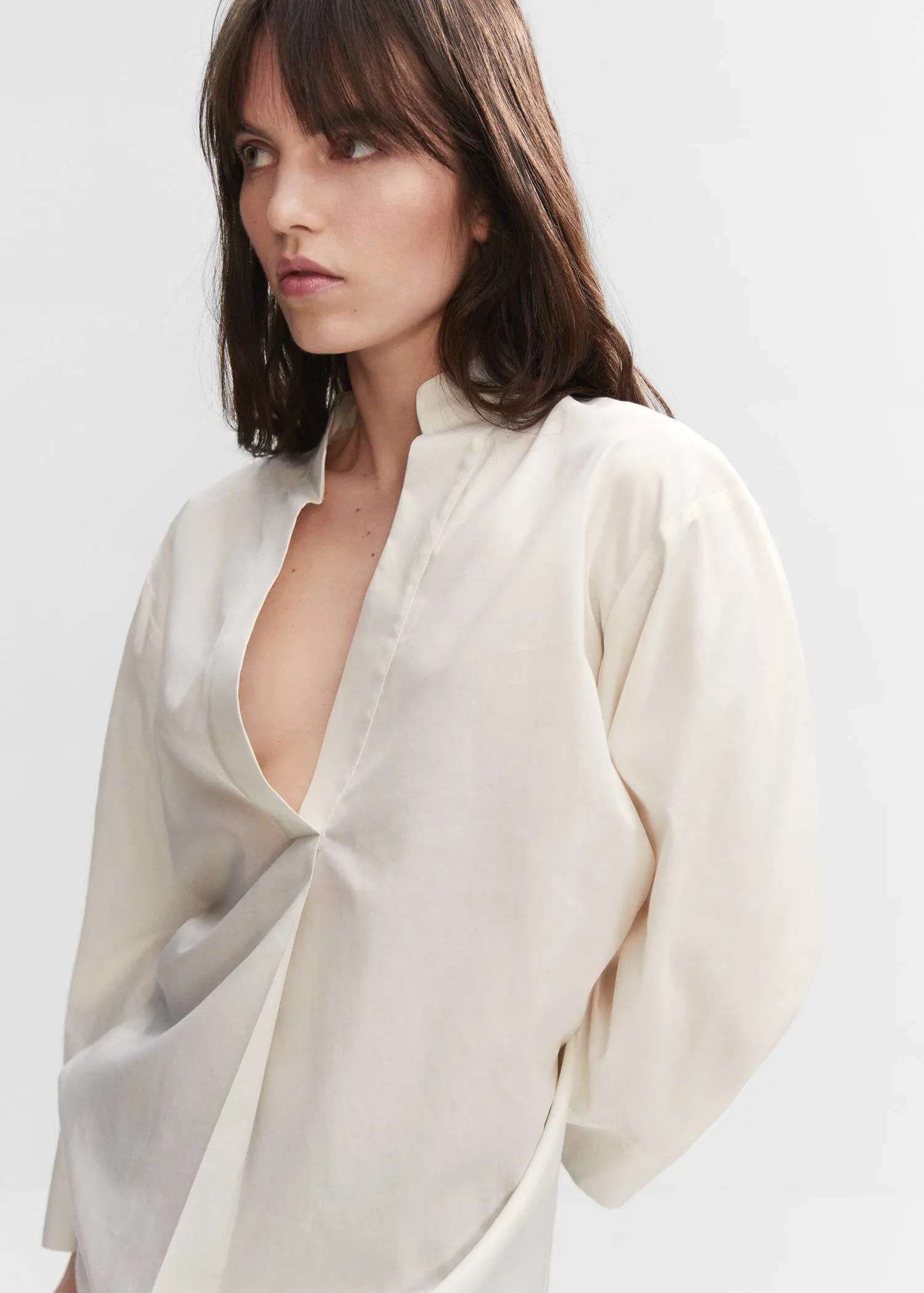 Mango Oversized V-neck blouse. a woman wearing a white shirt and a black dress. 