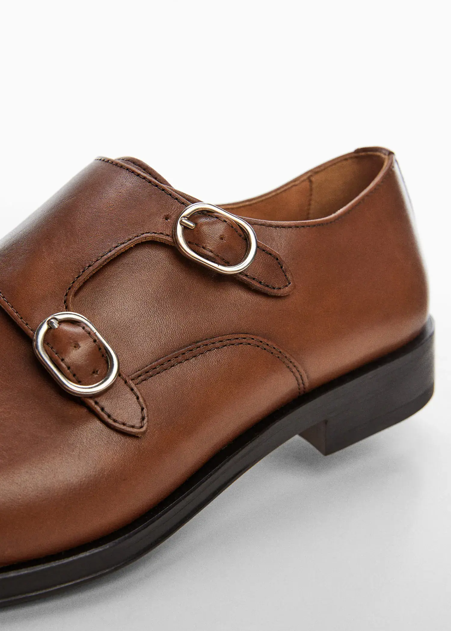 Mango Monk shoes with leather buckle. a close-up of a pair of brown shoes. 