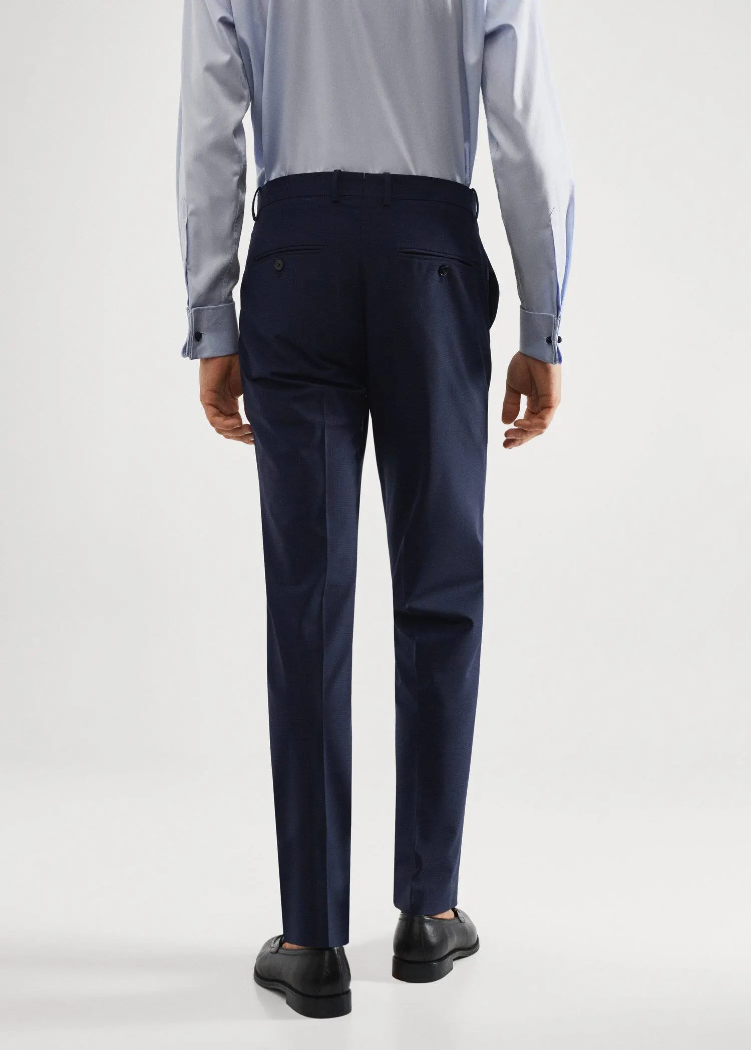 Mango Wool slim-fit check suit pants. a man wearing a suit standing in front of a white wall. 
