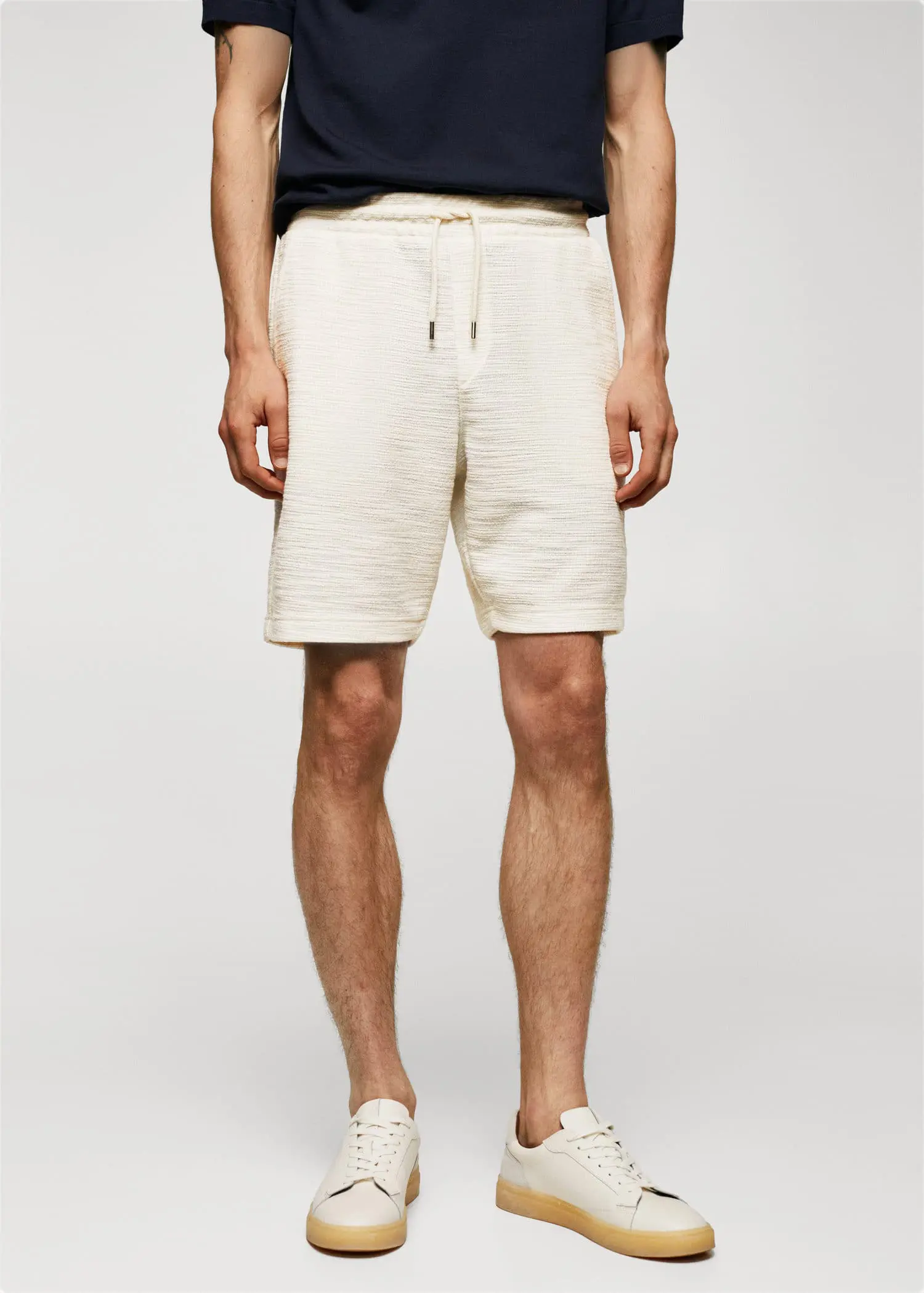 Mango Structured cotton Bermuda. a man in white shorts and a black t shirt. 