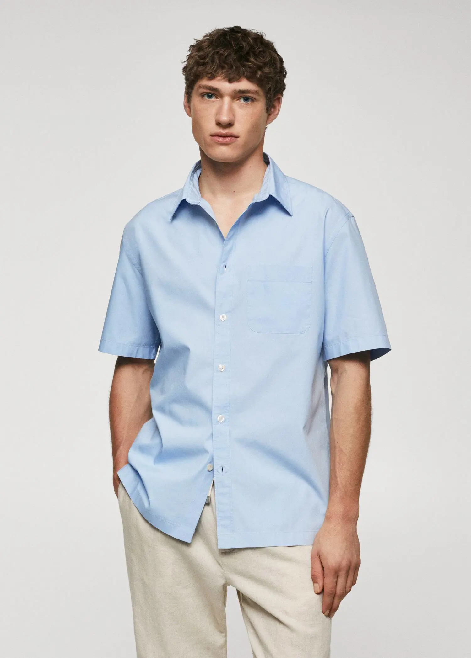 Mango Regular-fit cotton short sleeve shirt. a young man wearing a light blue shirt. 