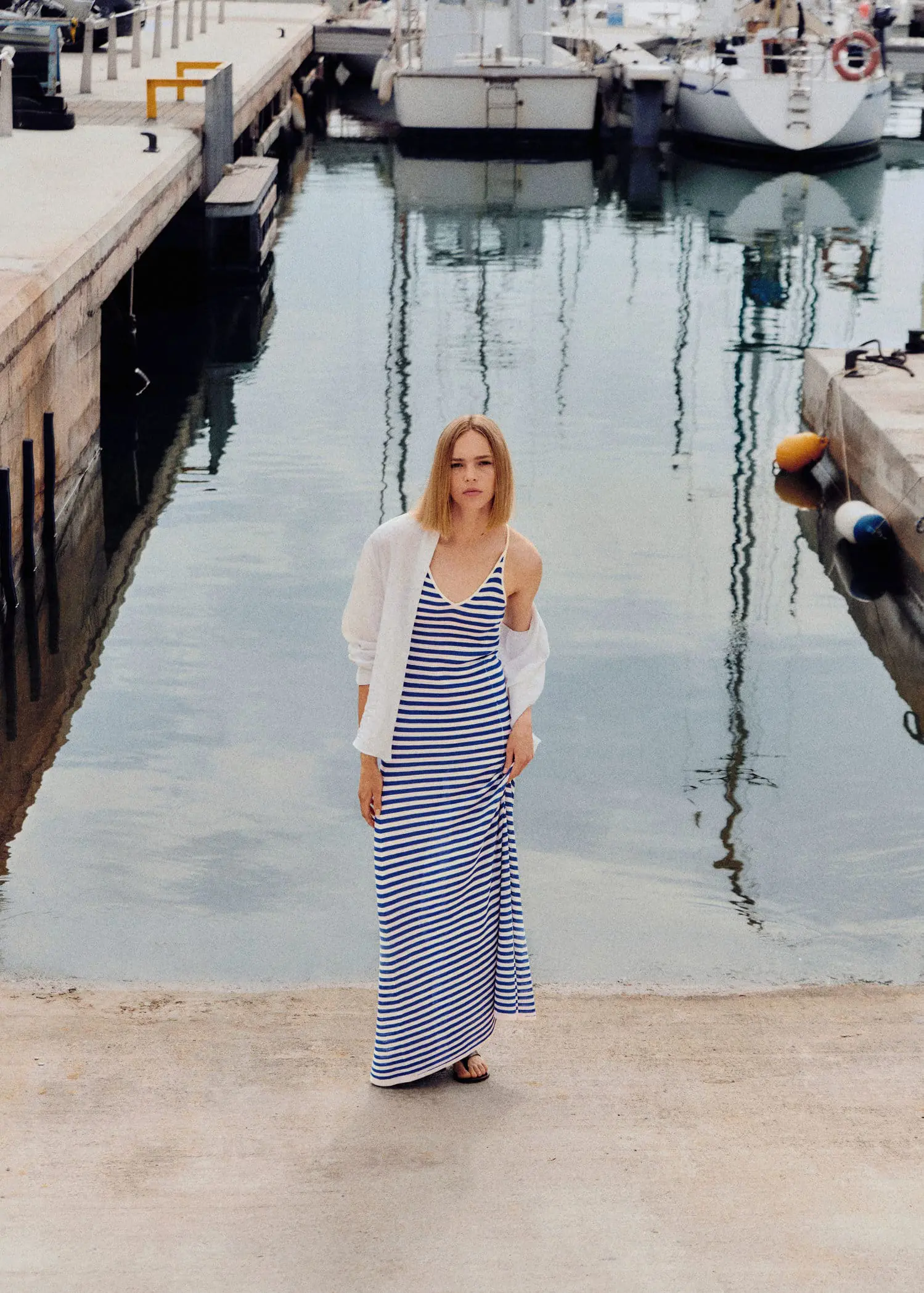 Mango Striped jersey dress. a woman standing in front of a body of water. 