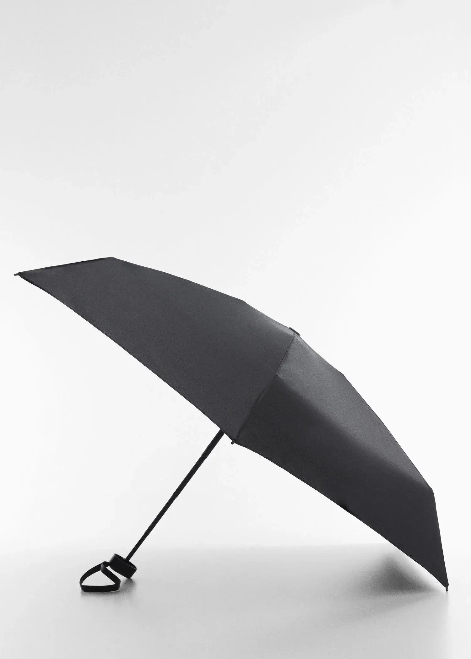 Mango Plain folding umbrella. an open black umbrella on a white surface. 