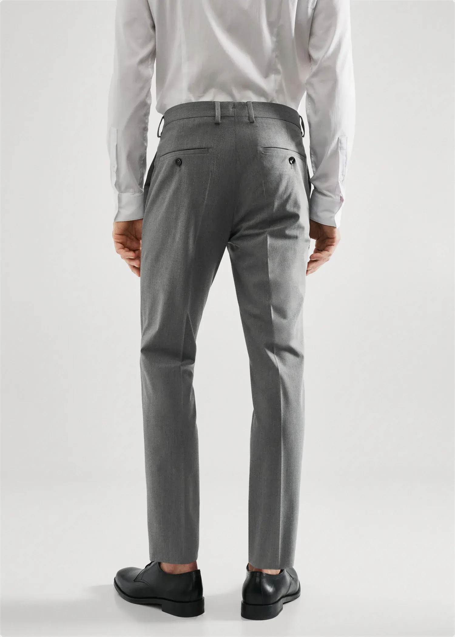 Mango Stretch fabric super slim-fit suit pants. a man wearing a suit standing in front of a white wall. 