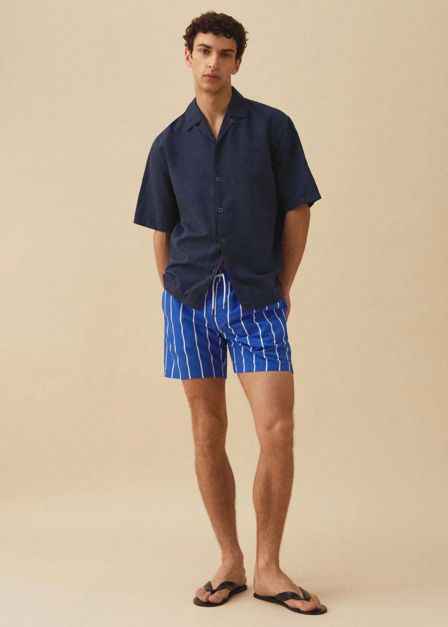 Mango Leather straps sandals. a man in a blue and white striped shorts. 
