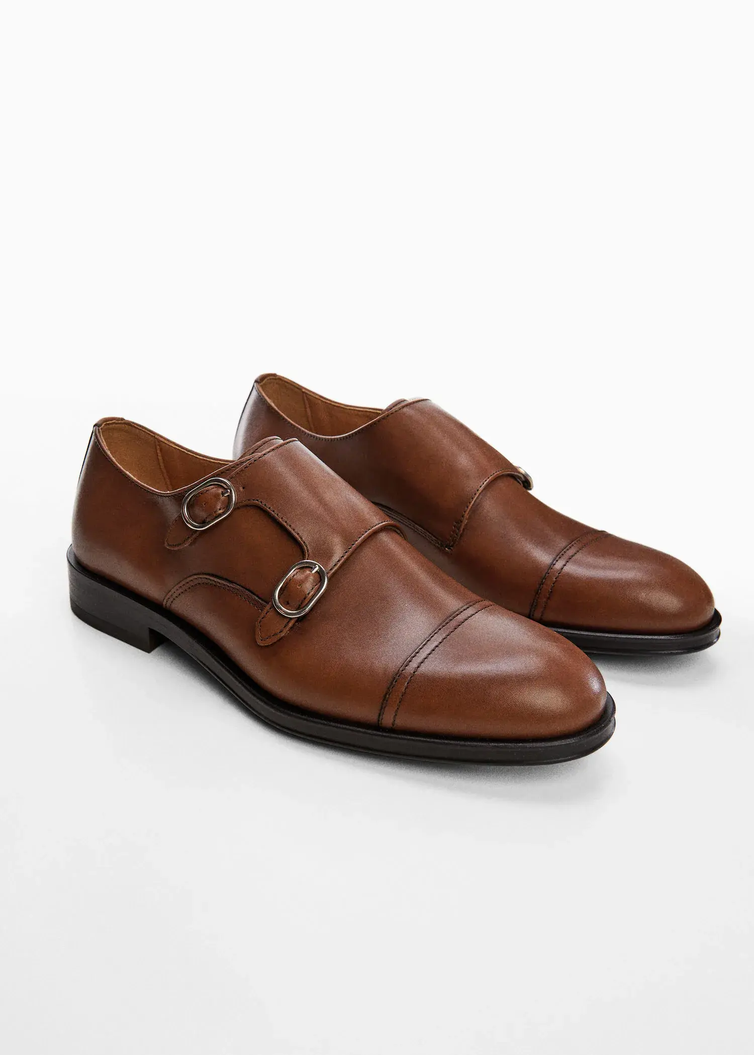 Mango Monk shoes with leather buckle. a pair of brown shoes on top of a white surface. 