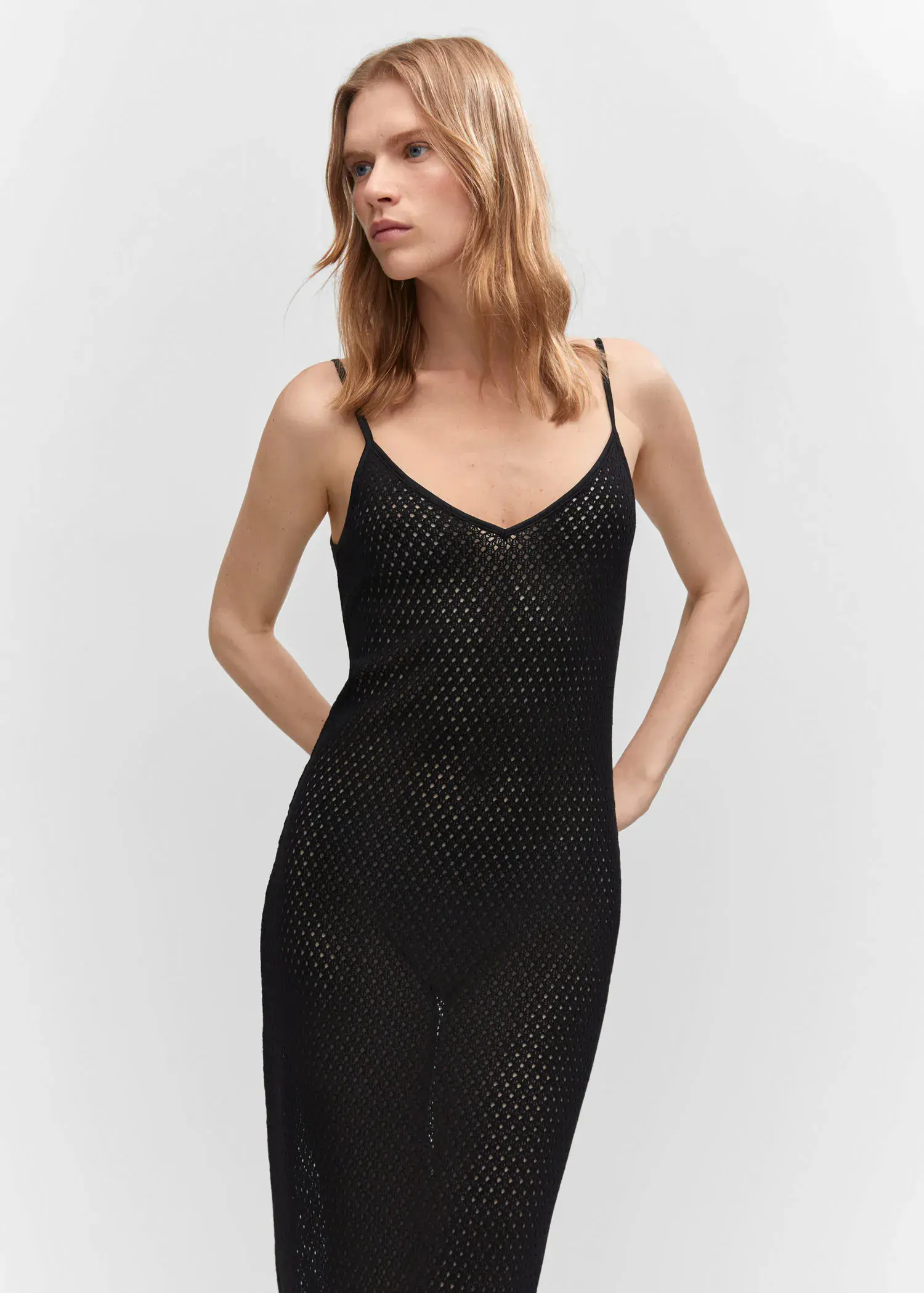 Mango Long openwork knitted dress. a woman in a black dress posing for a picture. 