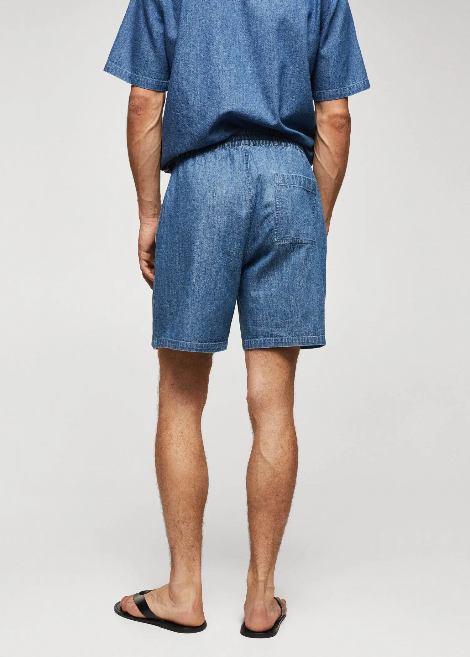 Mango Chambray Bermuda shorts. a man wearing a pair of blue shorts. 