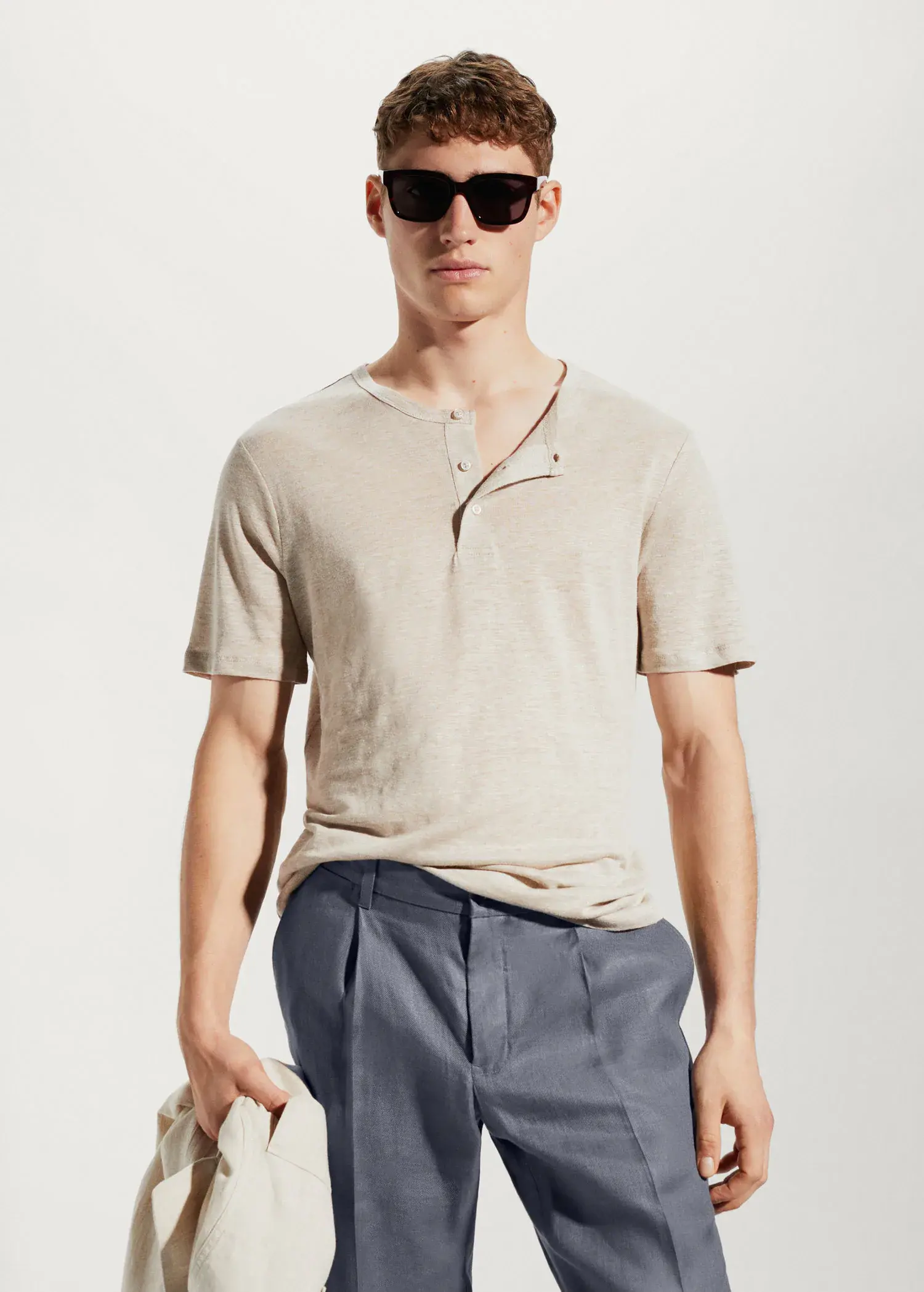 Mango 100% linen Henley t-shirt. a man wearing sunglasses standing in front of a white wall. 