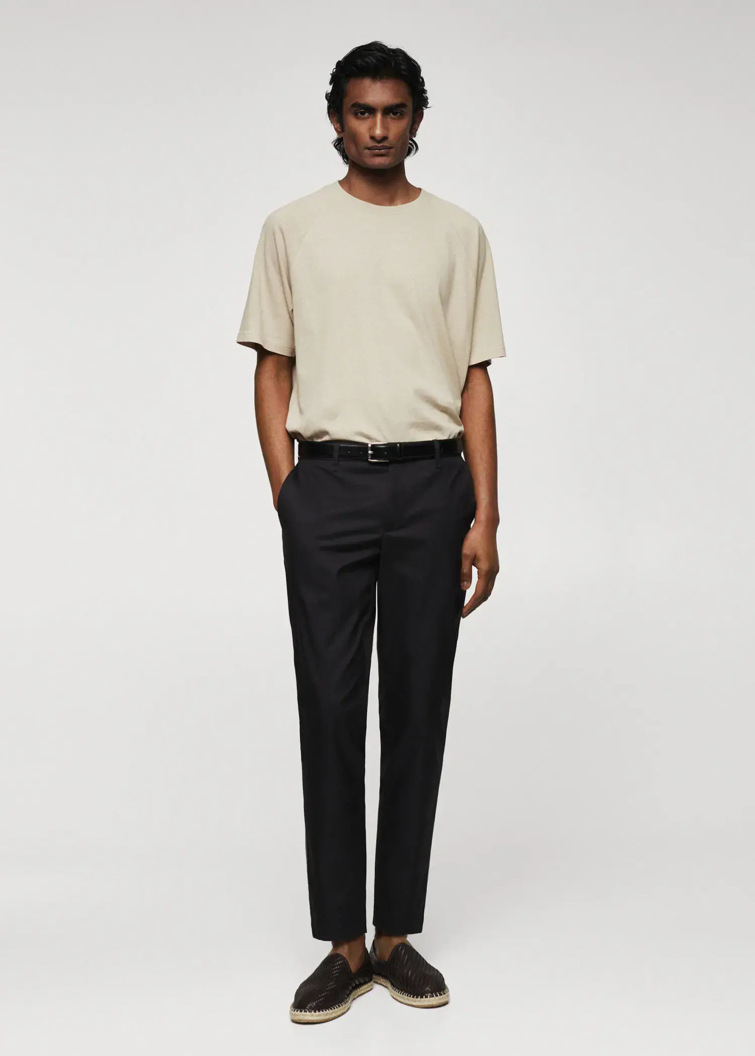 Mango Slim-fit cotton trousers. a man standing in front of a white wall. 