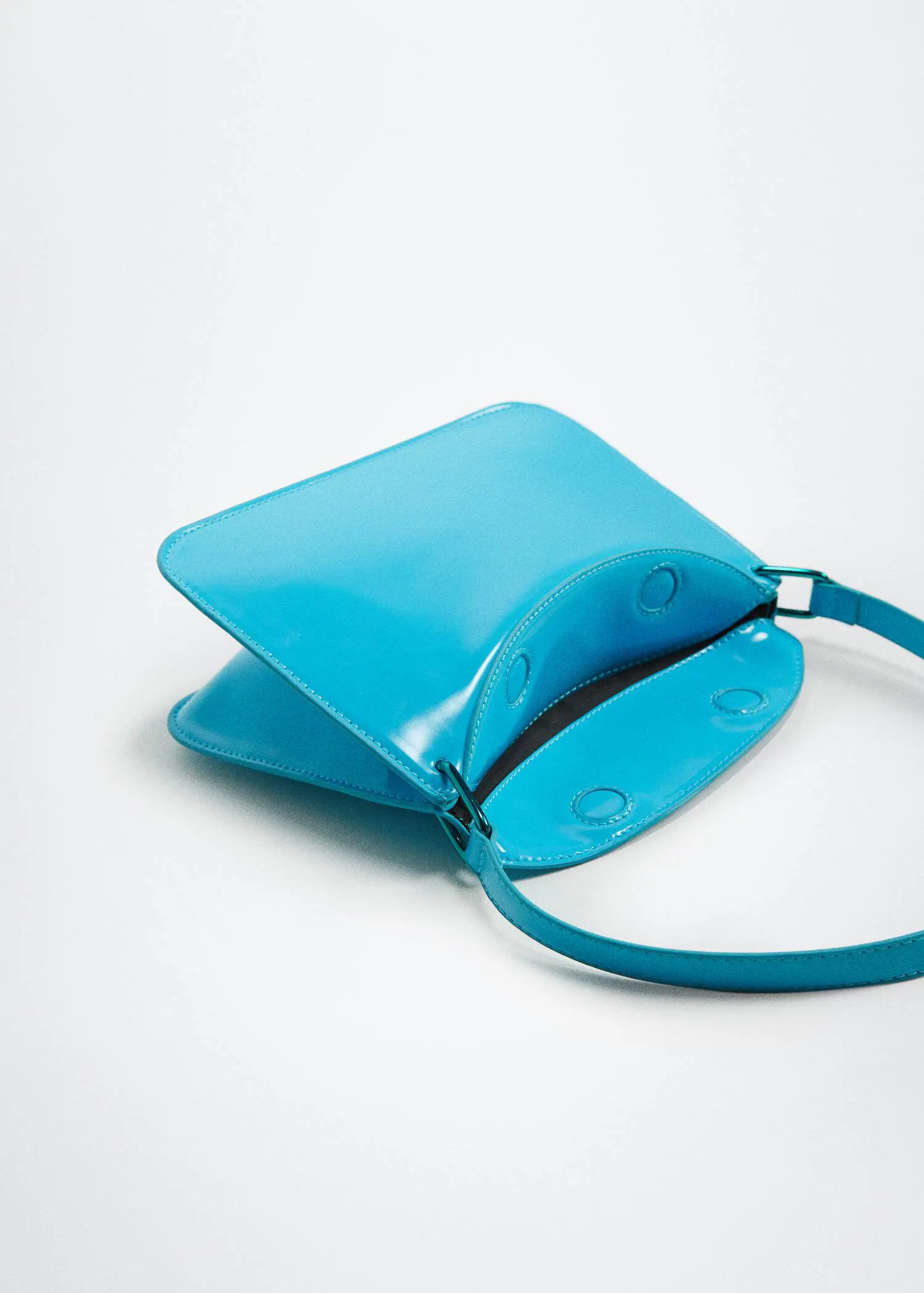 Mango Patent leather shoulder bag. a close up of a blue purse on a table 