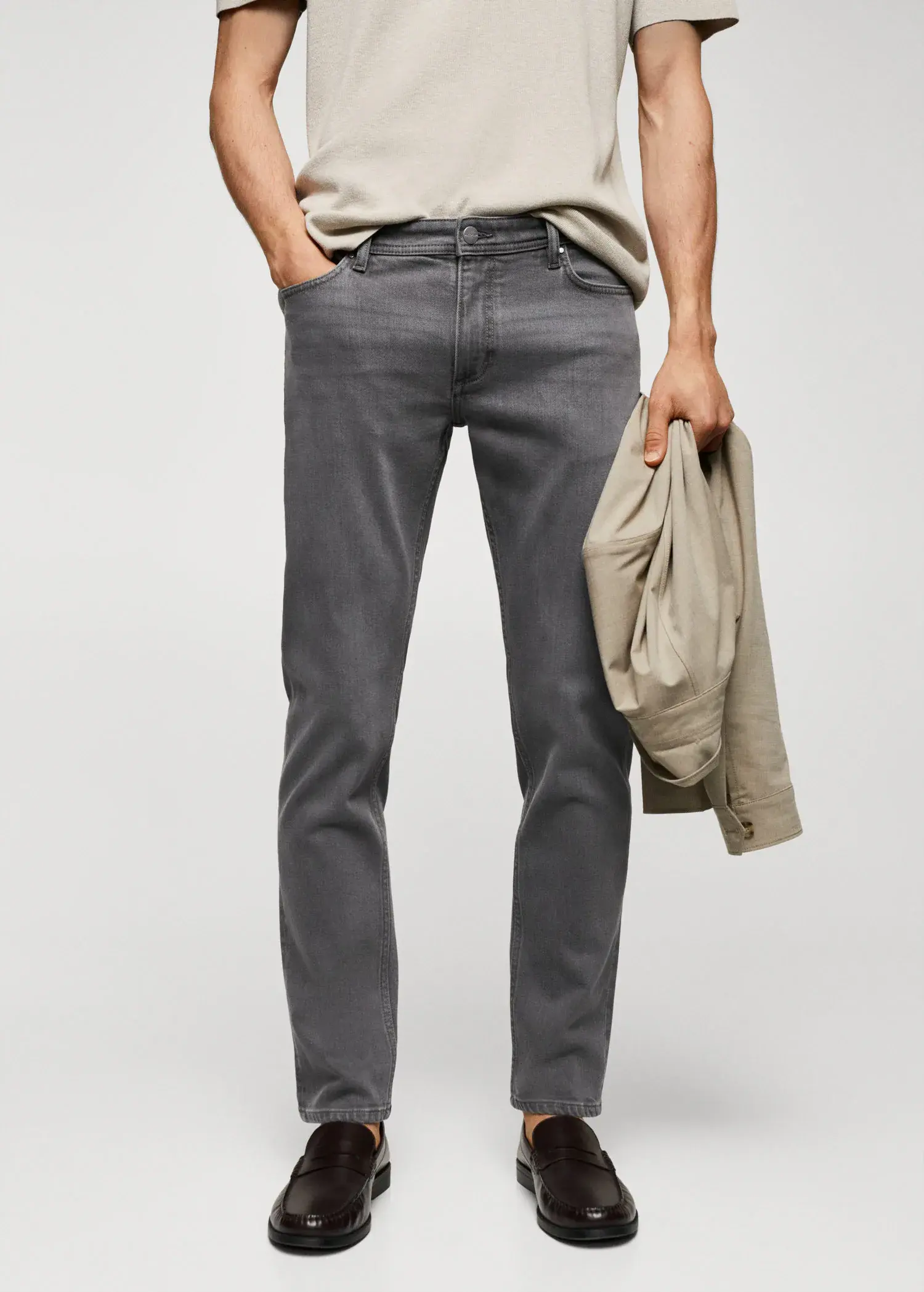 Mango Jan slim-fit jeans. a man in grey jeans holding a jacket. 