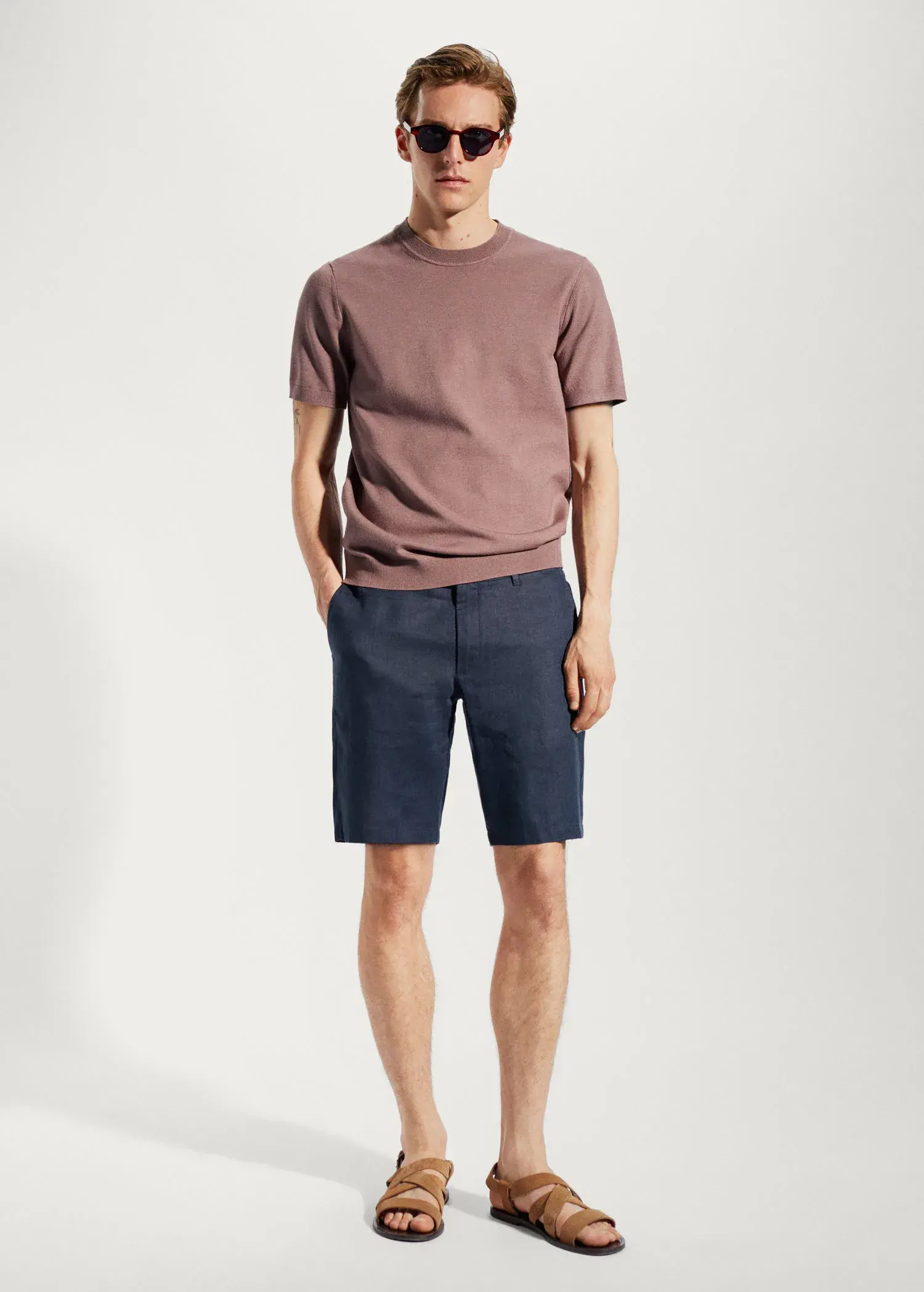 Mango 100% linen shorts. a man in a tan t-shirt and navy blue shorts. 