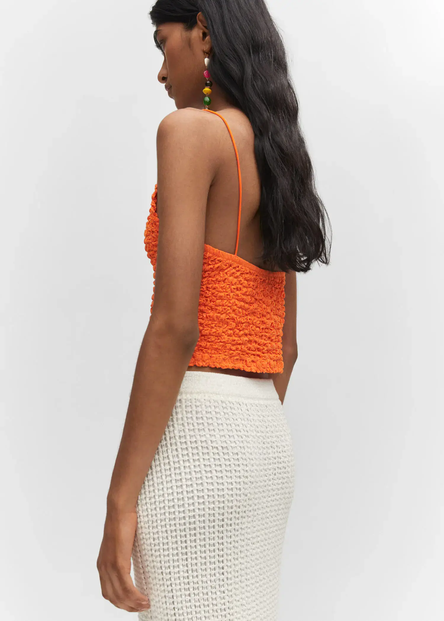 Mango Textured crop top. a woman wearing a white skirt and a bright orange top. 